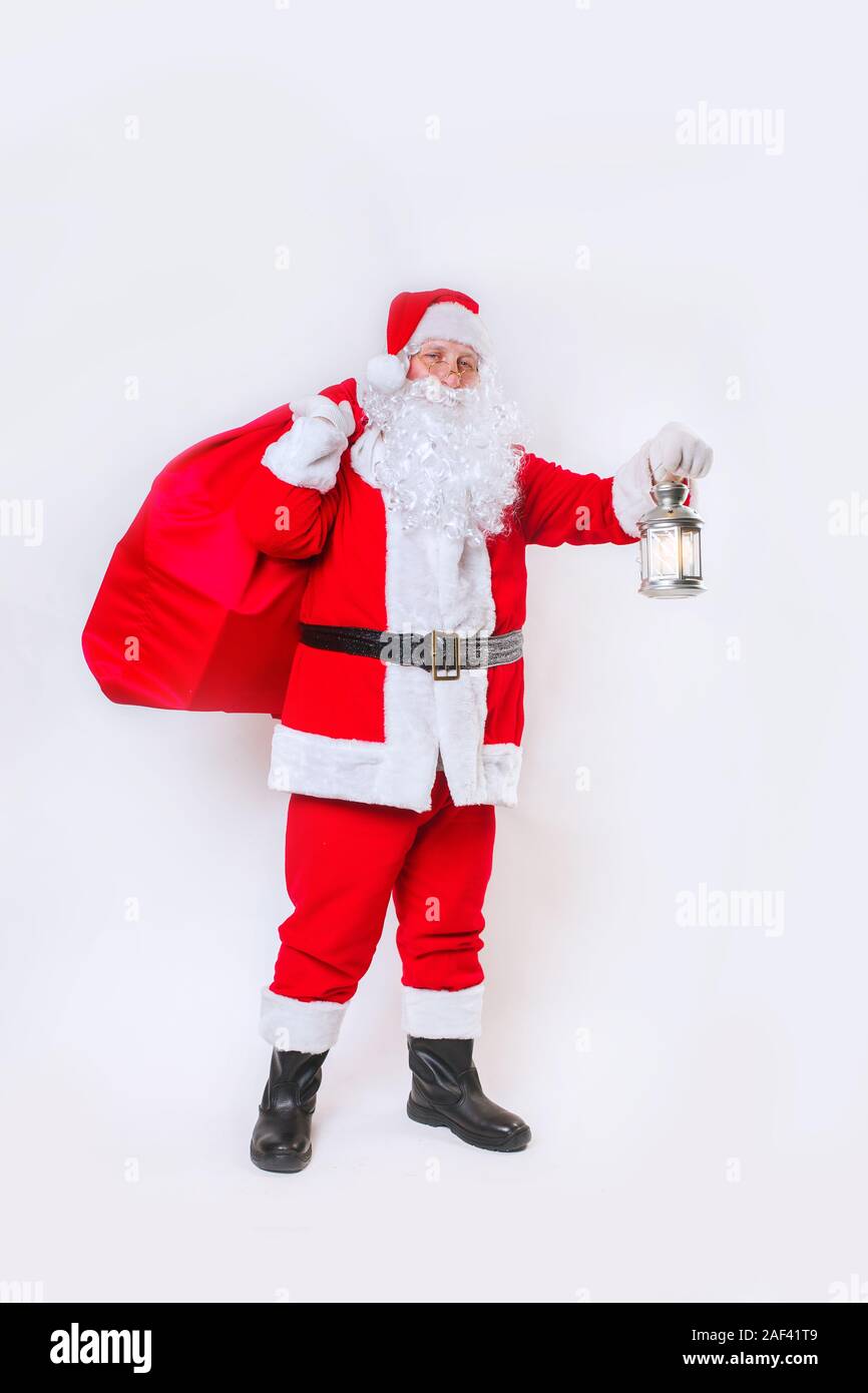 Santa Claus carrying big red bag full of gifts and light the road on ...