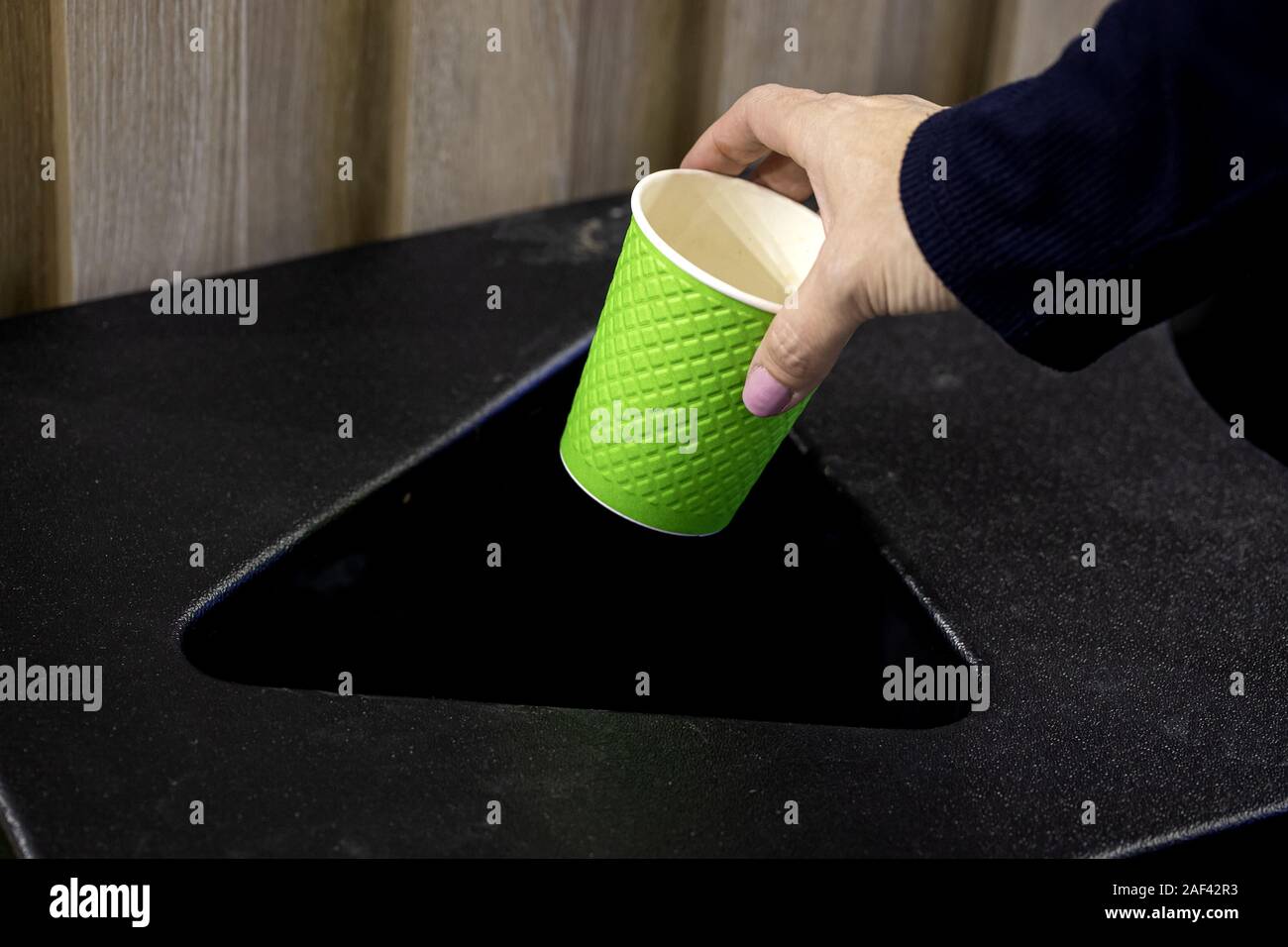 hand putting paper cup in to the bin Stock Photo - Alamy