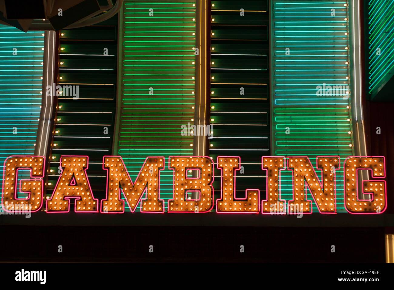 A gambling sign shines brightly outside a casino. Stock Photo