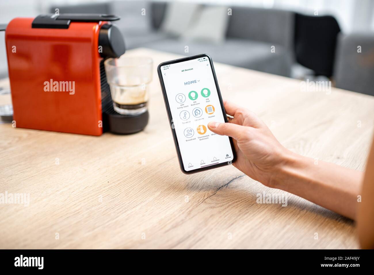 Modern coffee machine connected online with smartphone application. Concept of a smart home and