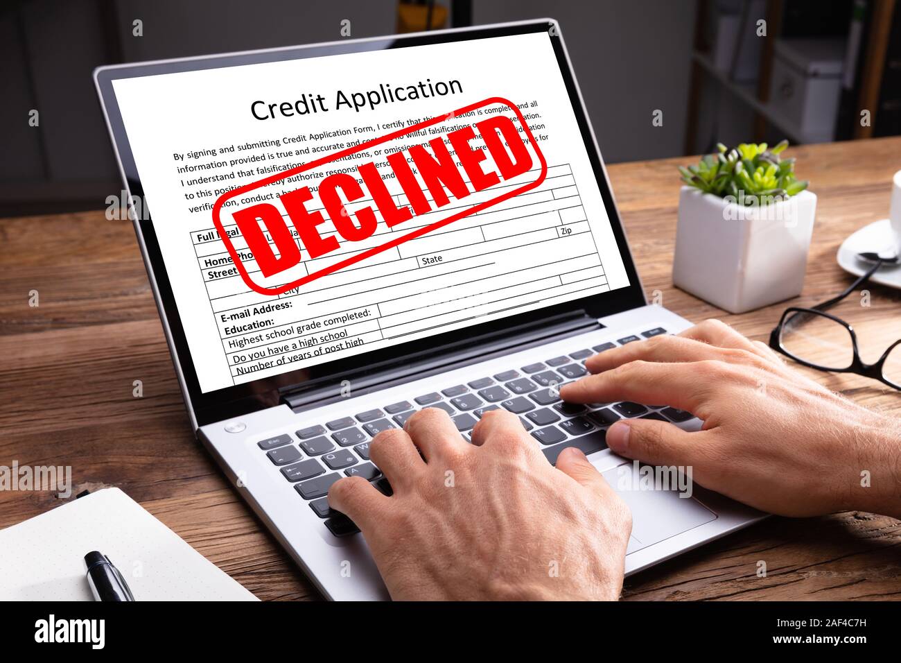 Person Typing On Laptop Keypad With Screen Showing Declined Message On Credit Application Stock