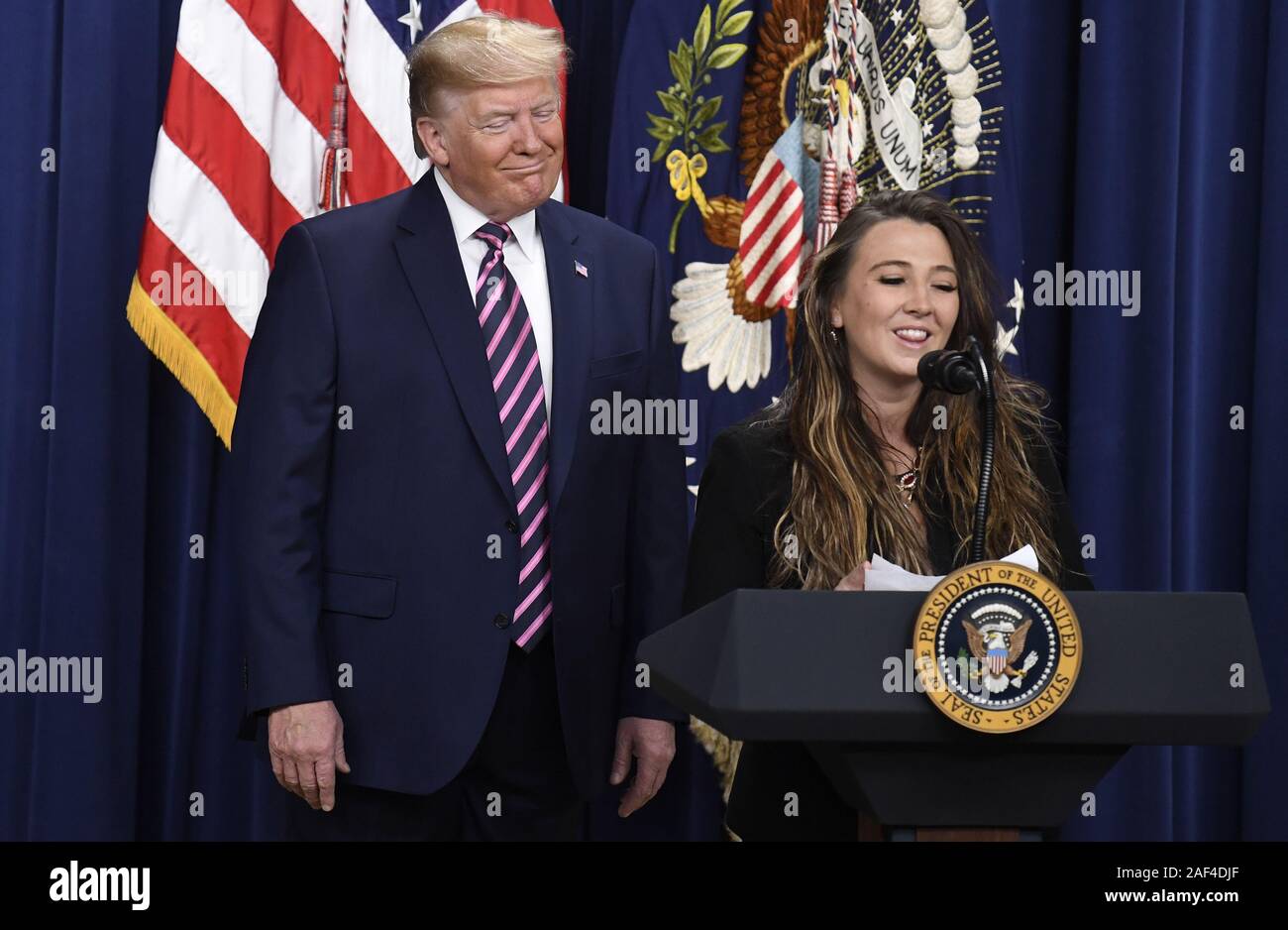 President Donald Trump (L) listens to remarks by child care facility worker Brittany Hasemann of Colorado during a White House Summit on Child Care and Paid Leave, Thursday, December 12, 2019, in Washington, DC. The House recently passed legislation granting federal workers 12 weeks paid parental leave.                                   Photo by Mike Theiler/UPI Stock Photo