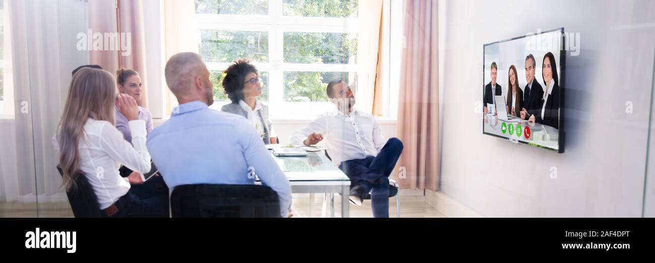 Group Of Diverse Businesspeople Video Conferencing In Boardroom Stock Photo