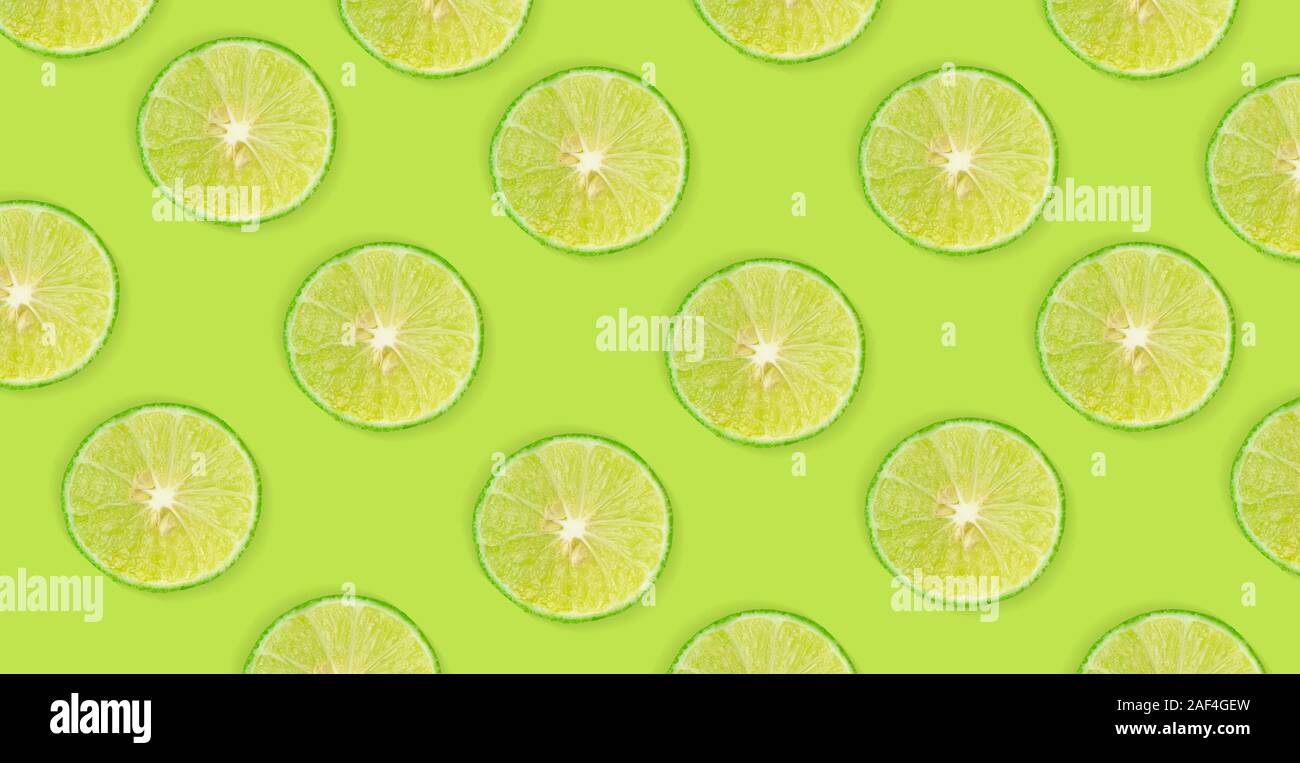 Fruit pattern of lime slices isolated on green background Stock Photo