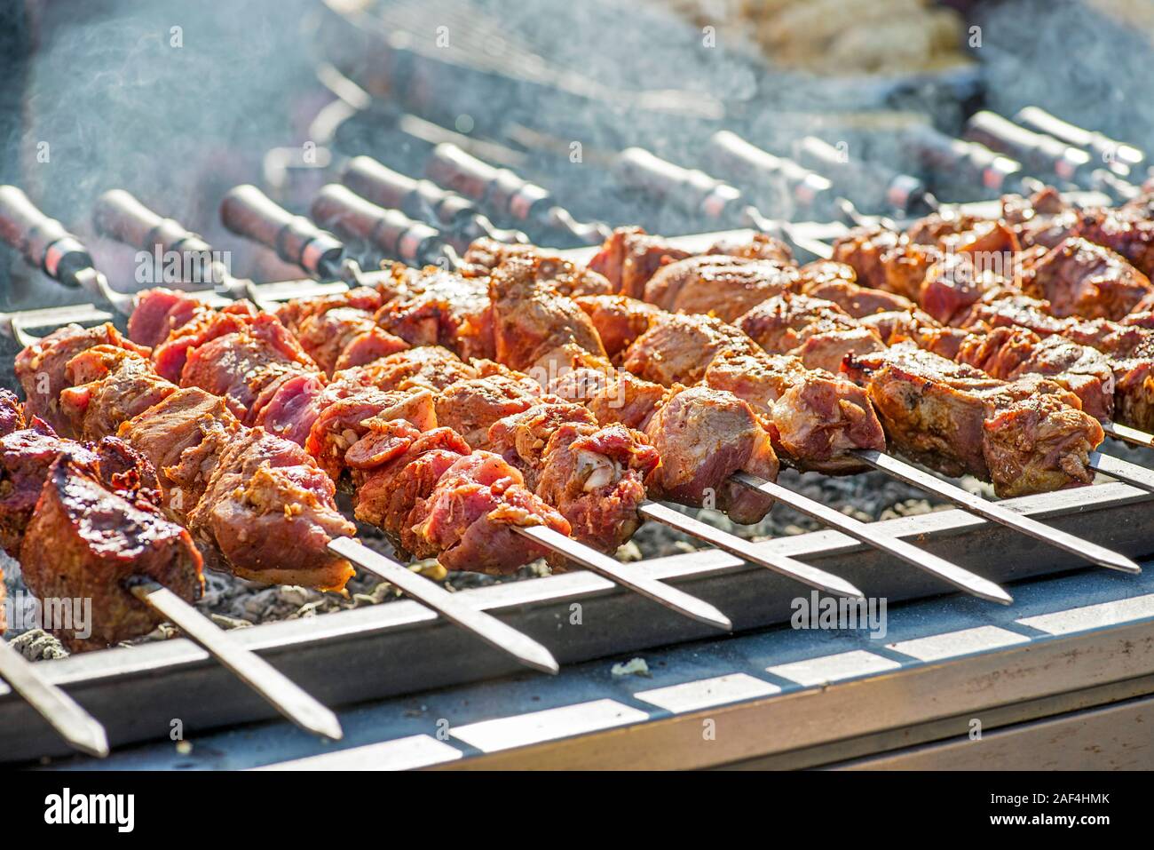 Pork on skewers cooked on barbecue grill. Preparation of shish kebab bbq. Stock Photo