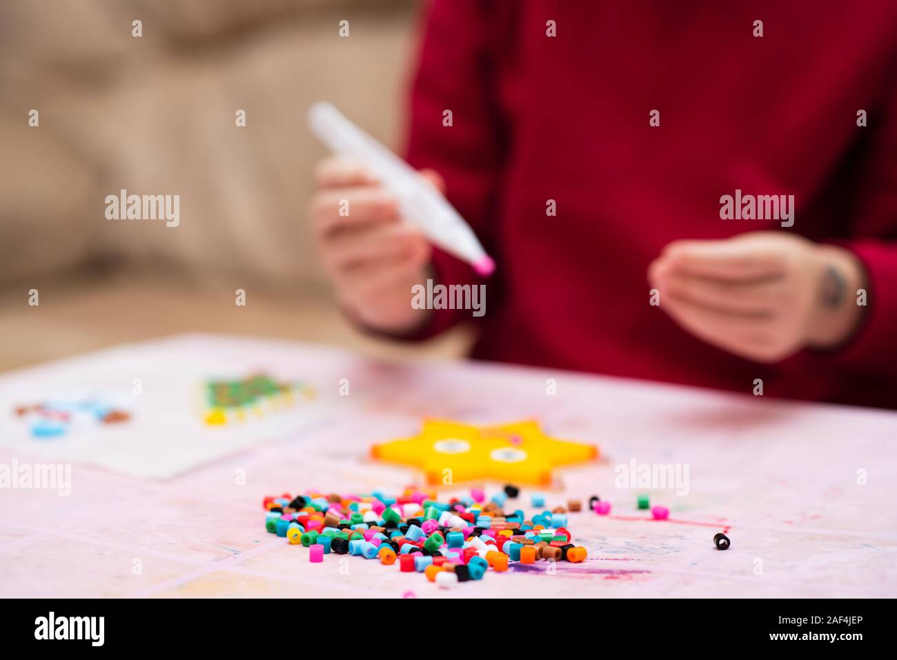 Colorful fusible beads or perler beads, on the children's table. Toy that develops the imagination of child. Soft blurred background with copy space Stock Photo