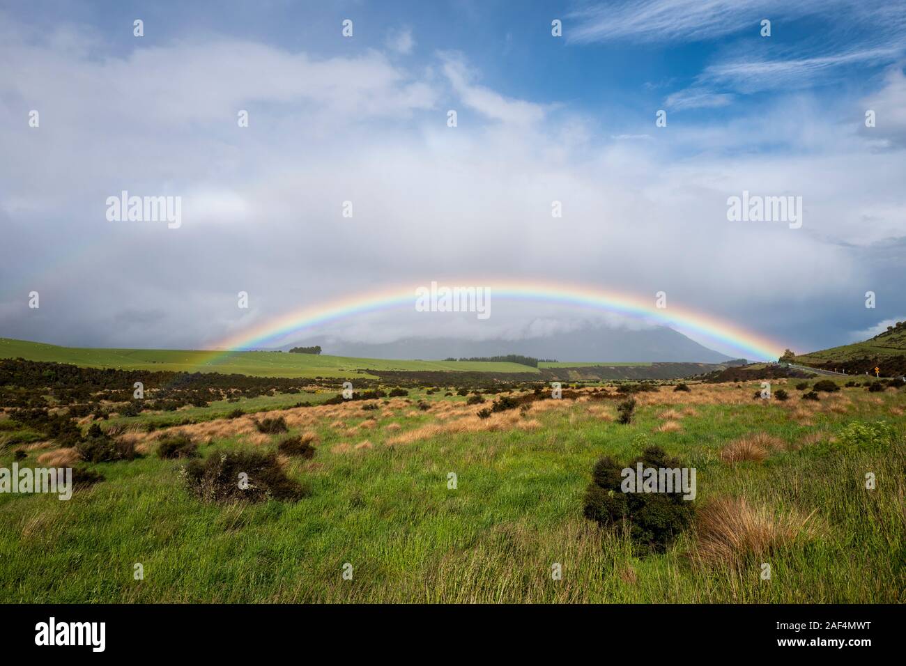 Rainbow over grassland near Invercargill on South Island, New Zealand, Aotearoa Stock Photo