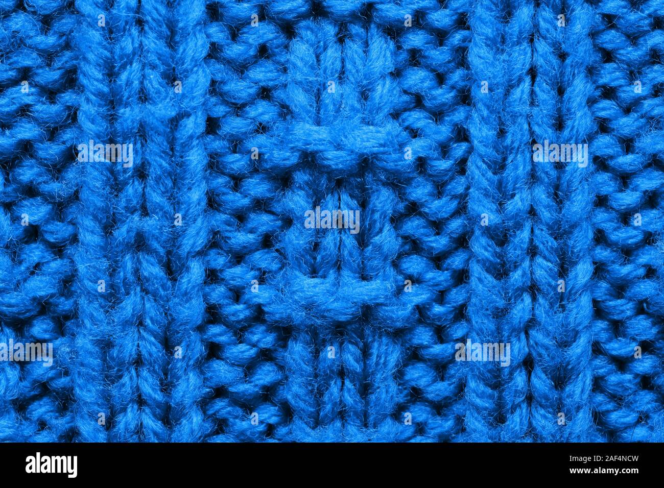 The texture of a knitted sweater. Blue pattern. Facial surface ...