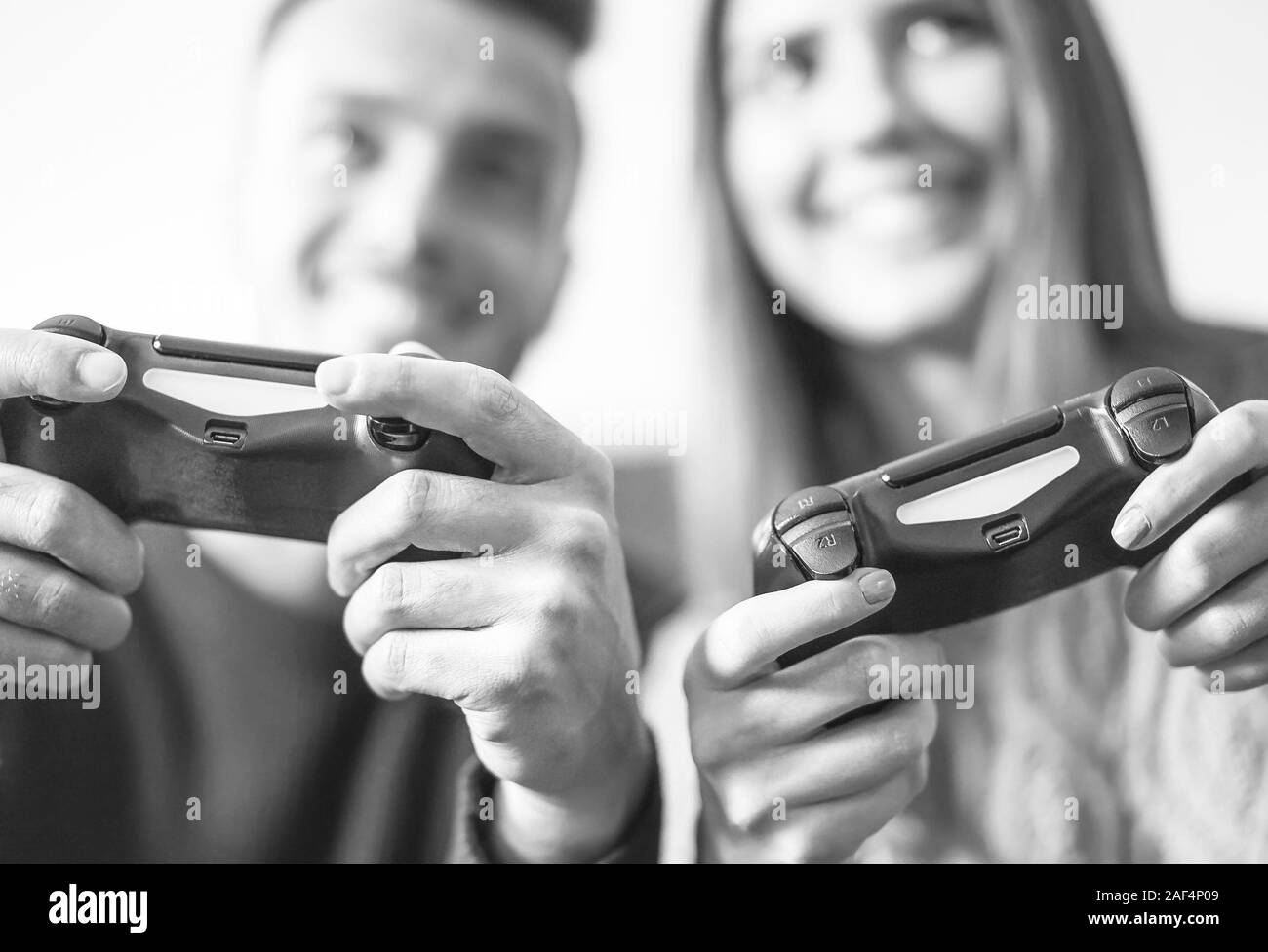 Excited couple playing video games at home - Happy young people having fun with new online trends technologies Stock Photo