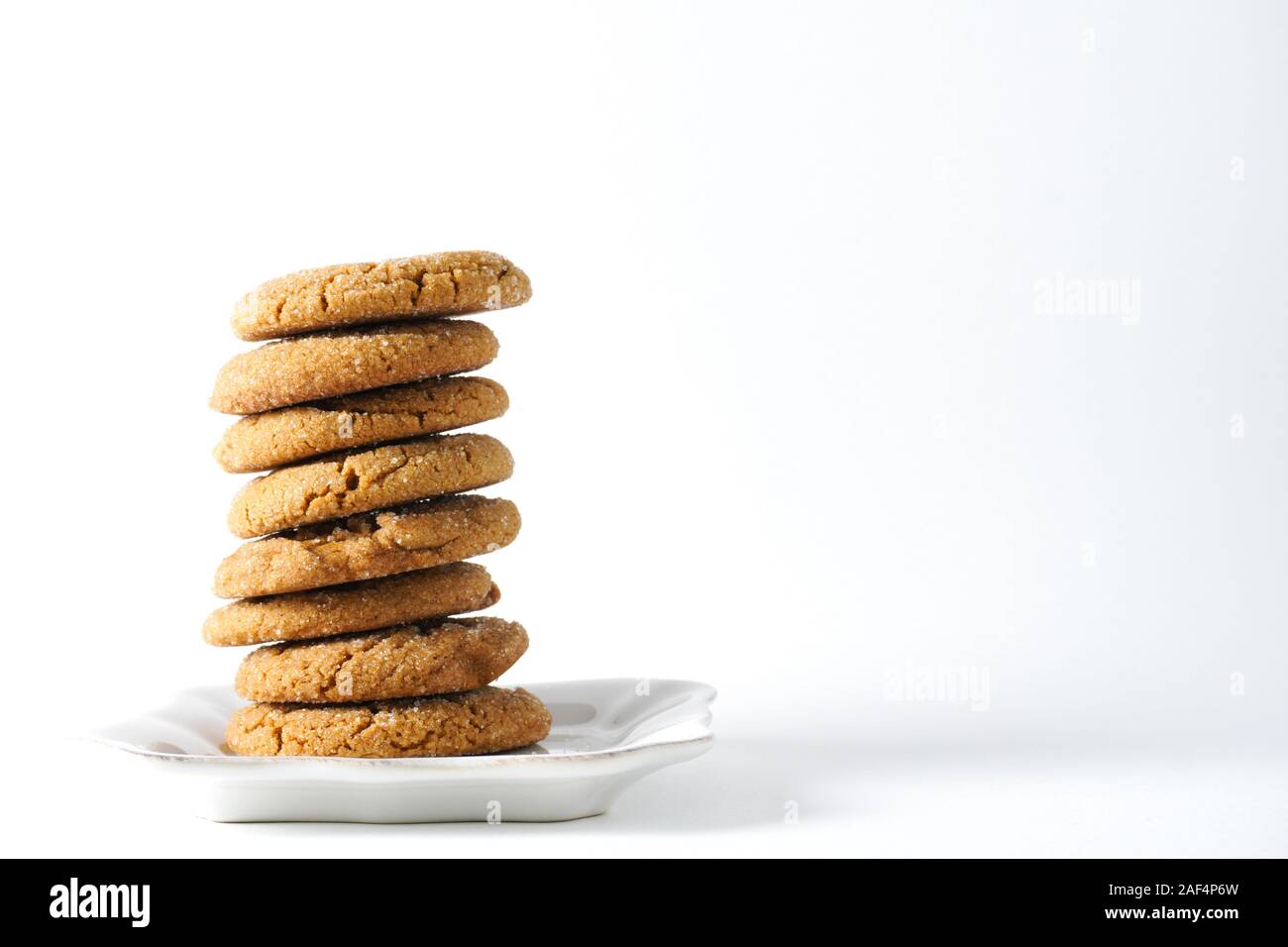 A pile of ginger cookies on a white plate with a white background and copy space on the right Stock Photo