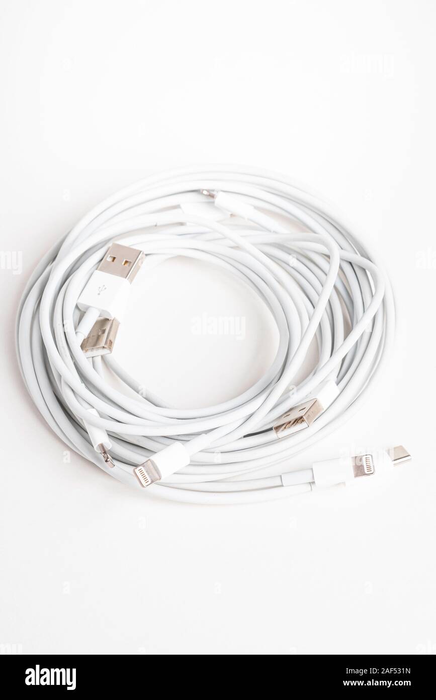 Vidalia, Georgia / USA - September 8, 2019: Several white Apple power cables and connectors in an organized swirl on plain white background. Stock Photo