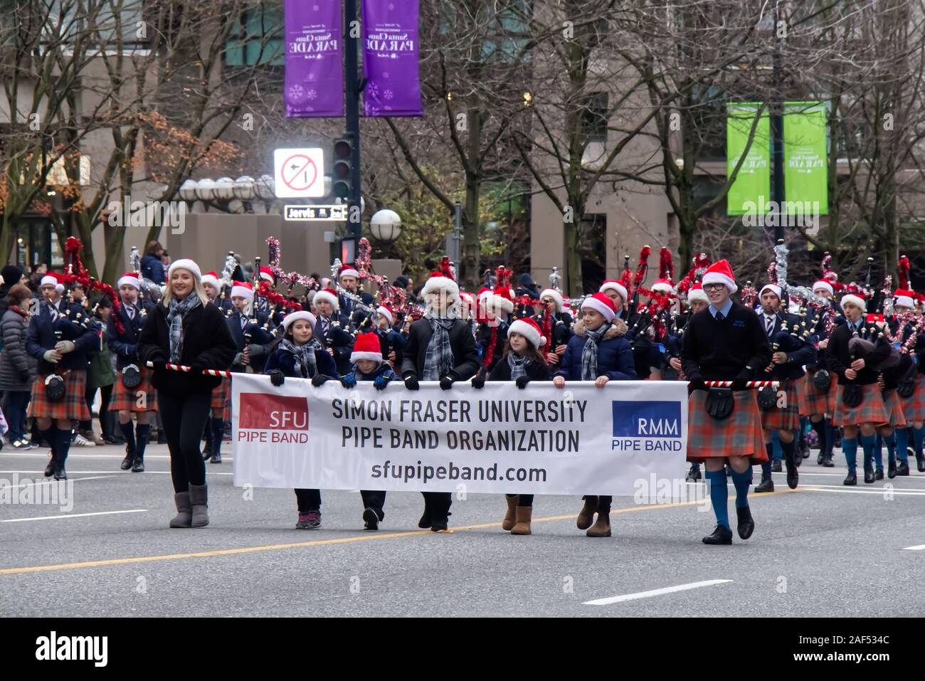 Vancouver, Canada - Dec 1, 2019: A Group of people from Simon Fraser University Pipe Band Organization takes part in the annual Santa Claus Parade Stock Photo