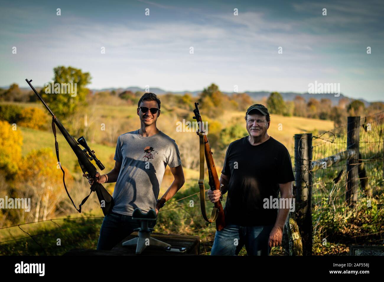 father and son holding rifles at outdoor gun range in Kentucky Stock