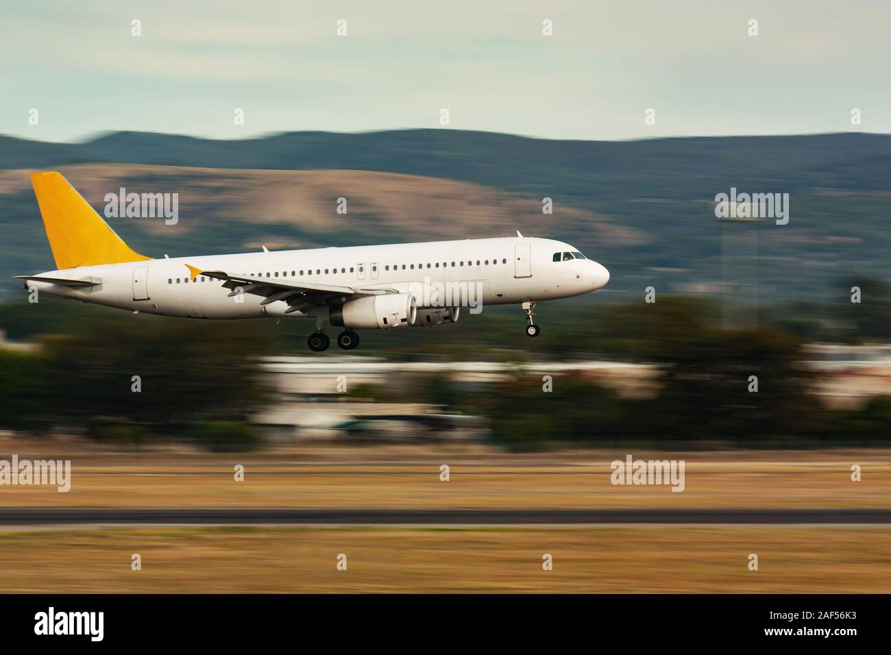 Panning shot of passenger airplane landing on runaway Stock Photo