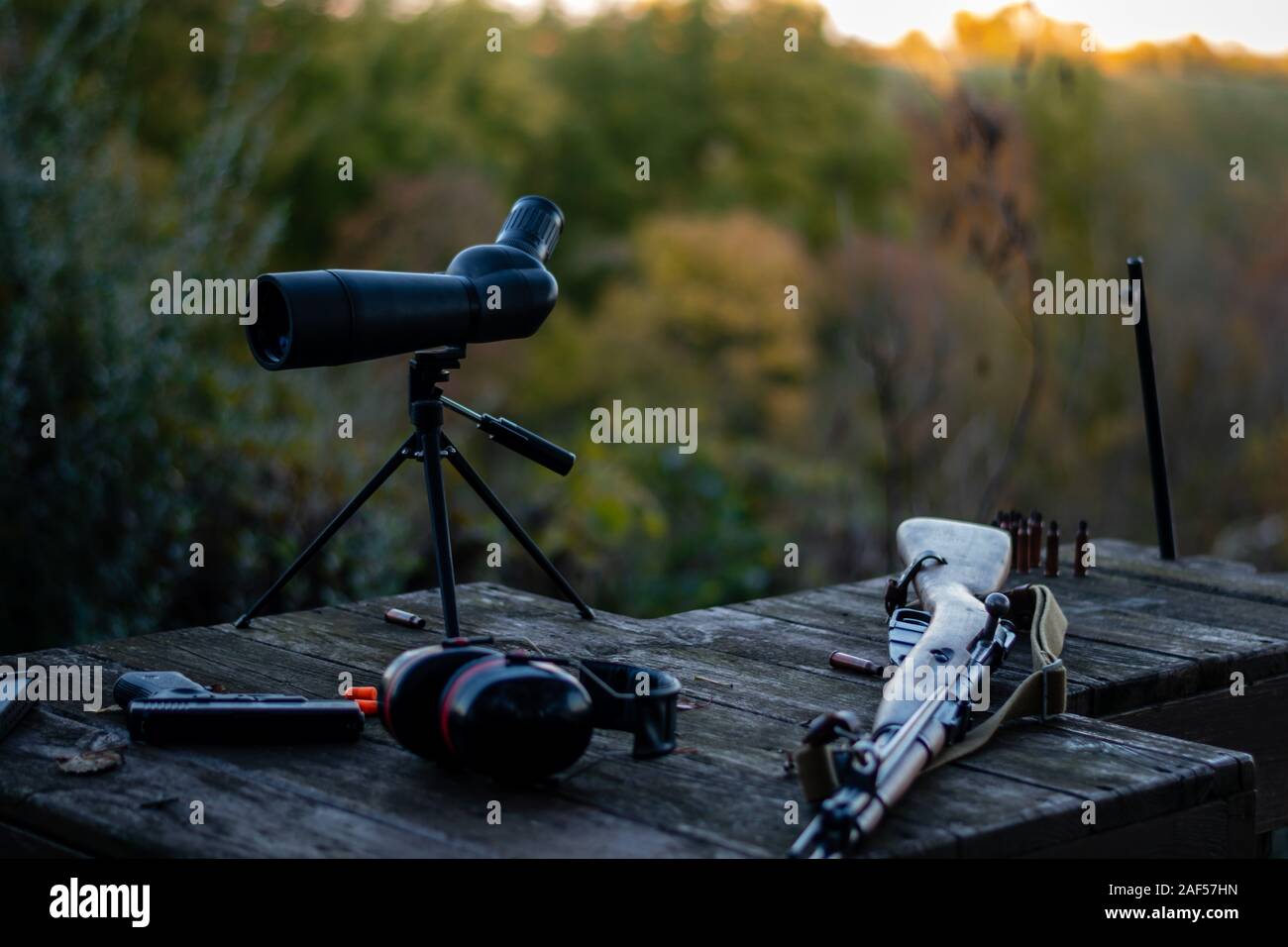 guns on table. spotting scope hearing protection handgun/pistol and old