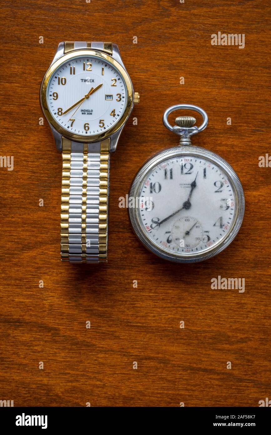 Old worn Monarch men's pocket watch compared to more modern Timex wristwatch in California. Pocket watch made by Joseph Fahys & Co. watchmakers N.Y. Stock Photo