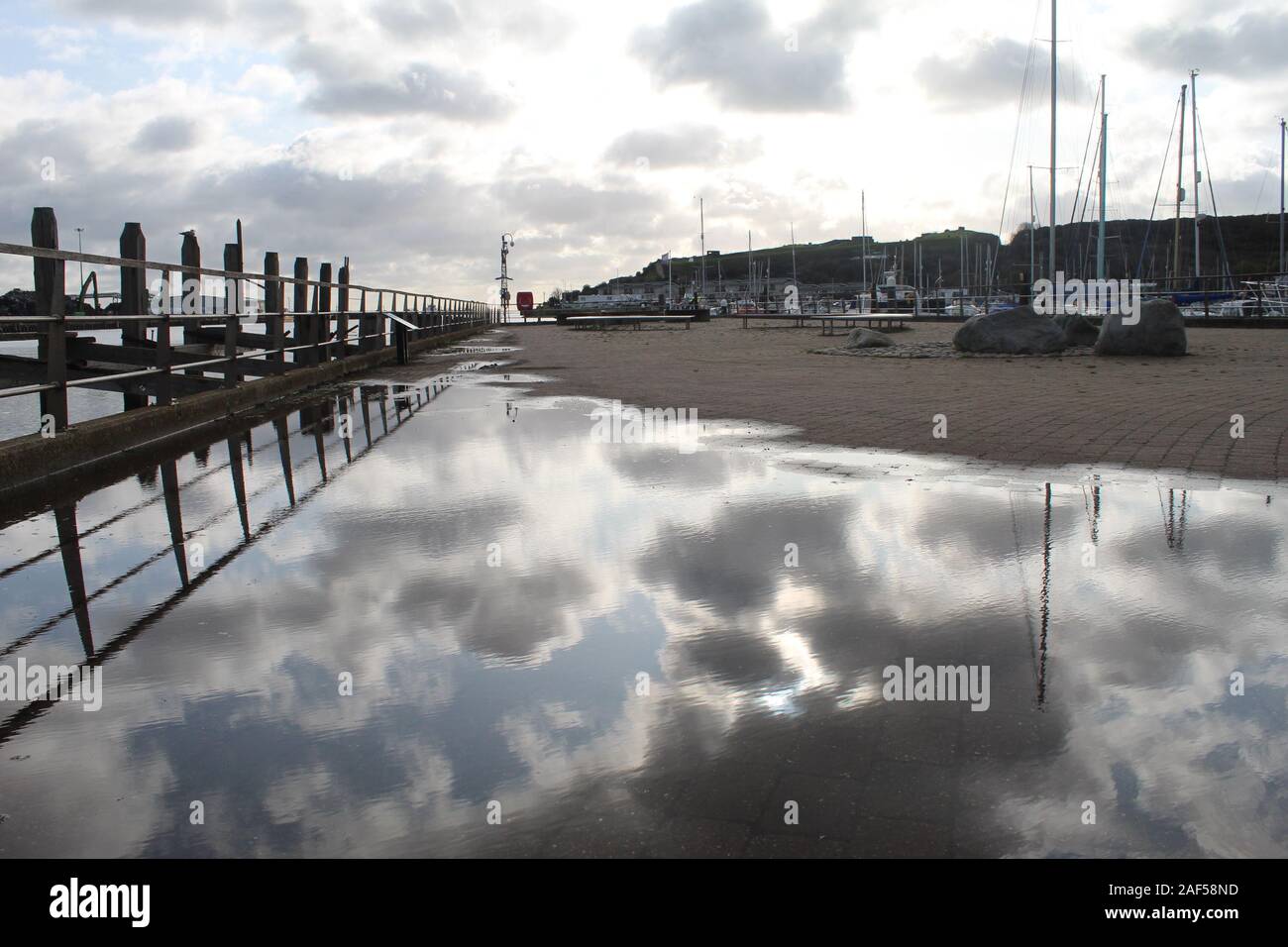Puddle reflection along Newhaven Harbour Stock Photo