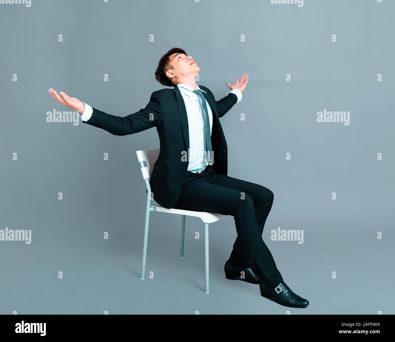 young business man sitting and looking up Stock Photo