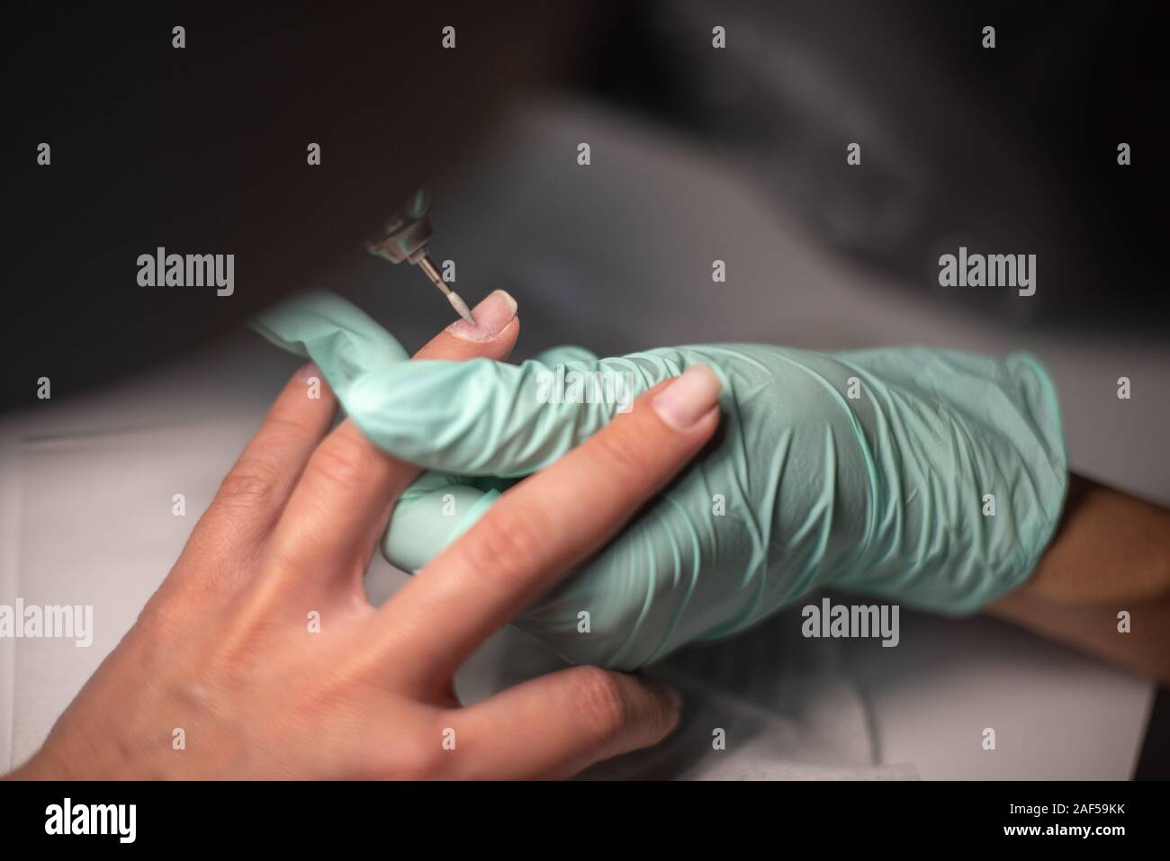 Manicule Hand A manicure hand with a nail lies on a manicure hand in blue hygienic ...