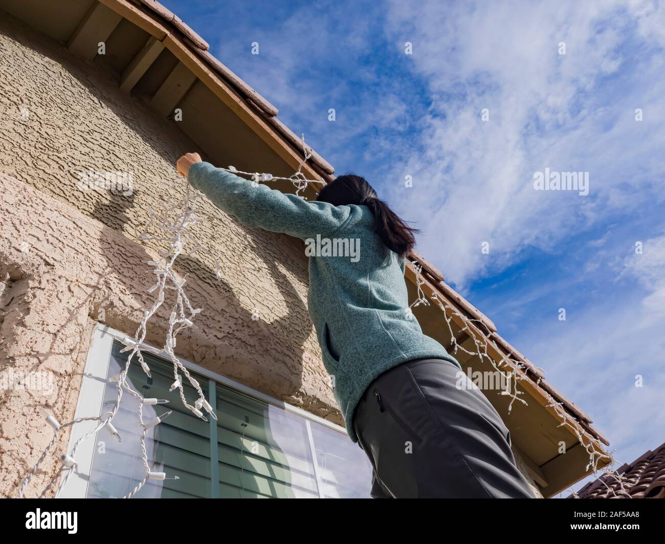 Woman hanging Christmas lights on the roof at Las Vegas, Nevada Stock Photo