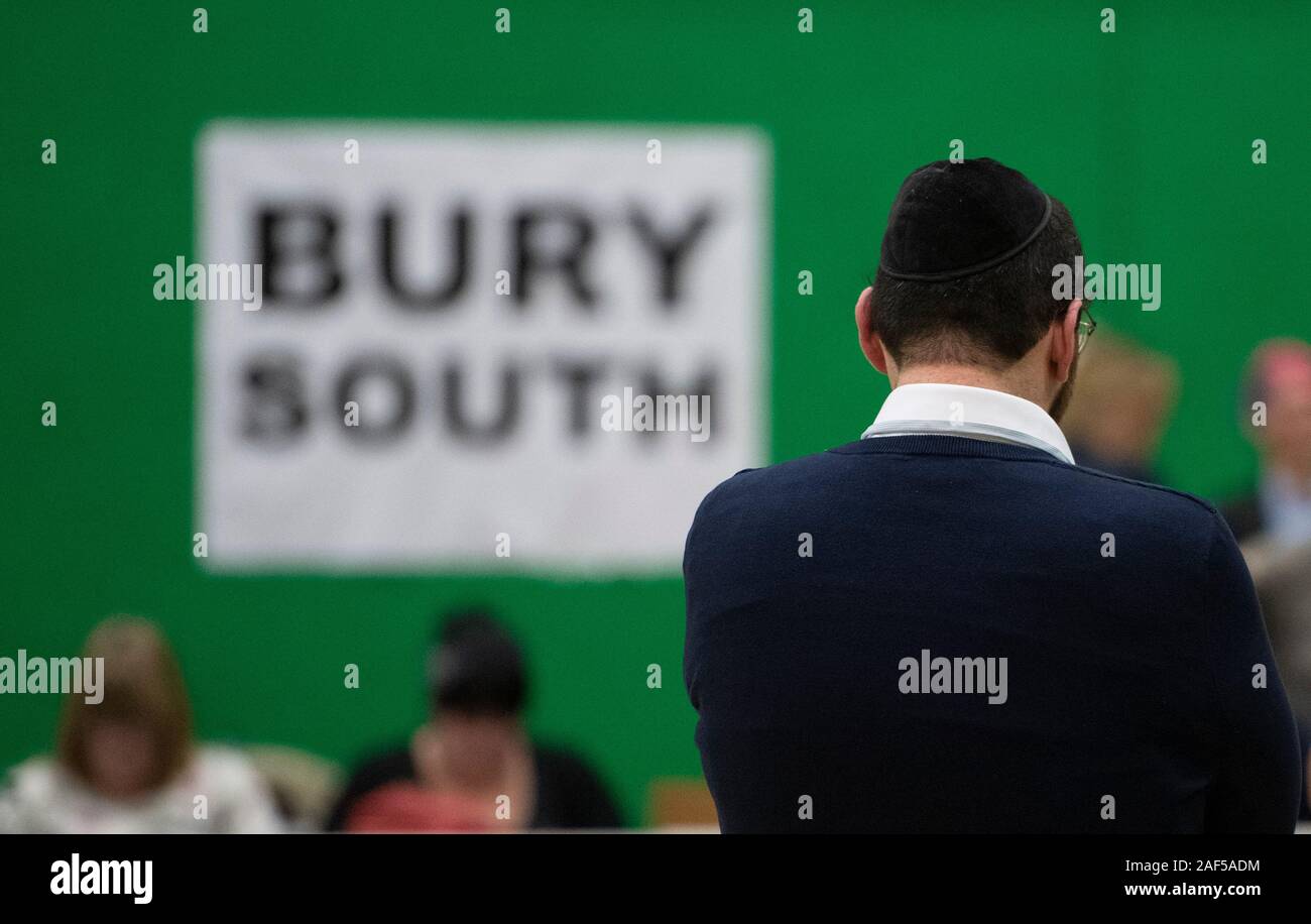 Bury, UK. 13th December 2019. A man wearing a skull cap stands in the counting hall of the Bury South constituency as votes are counted. Ivan Lewis, the constituency's MP until November 2019, resigned from the Labour party referring to his dissatisfaction with the party's record on antisemitism. Credit: Russell Hart/Alamy Live News Stock Photo