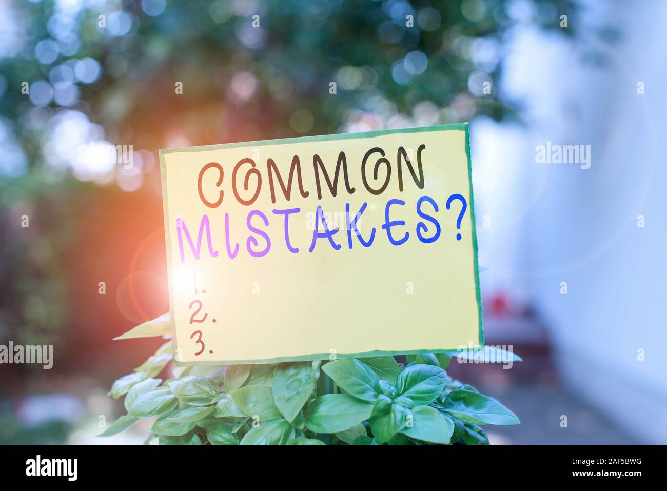 Writing note showing Common Mistakes Question. Business concept for repeat act or judgement misguided making something wrong Plain paper attached to s Stock Photo