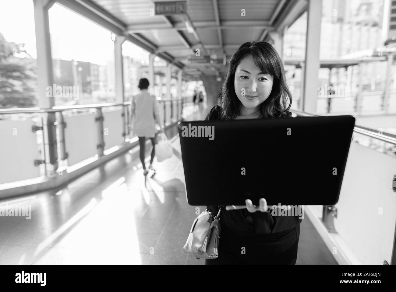 Mature beautiful Asian woman exploring around the city Stock Photo - Alamy