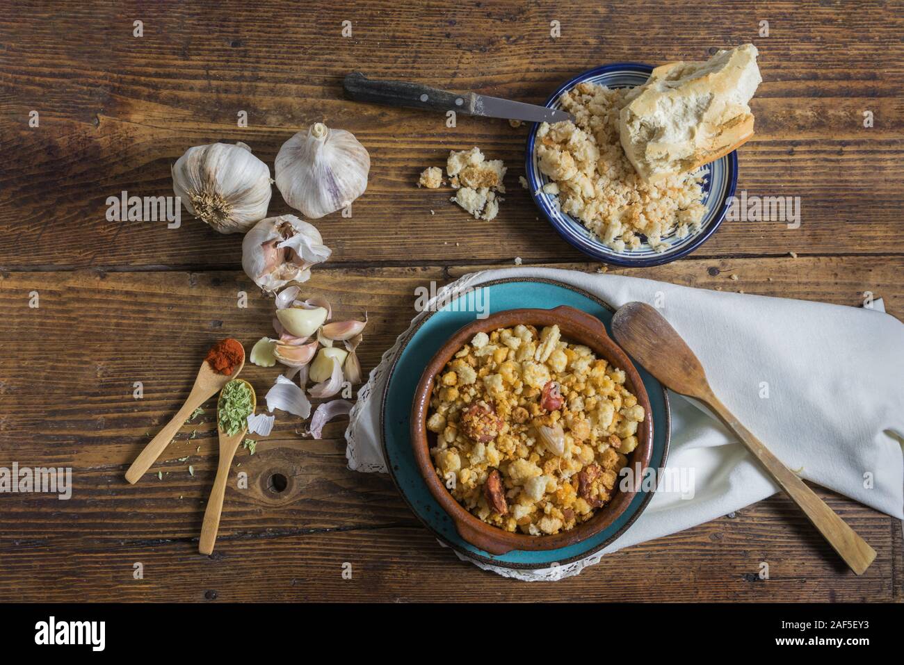 Still life with bread on a dark wooden background, crumbs with sausage. Dark food photography Stock Photo