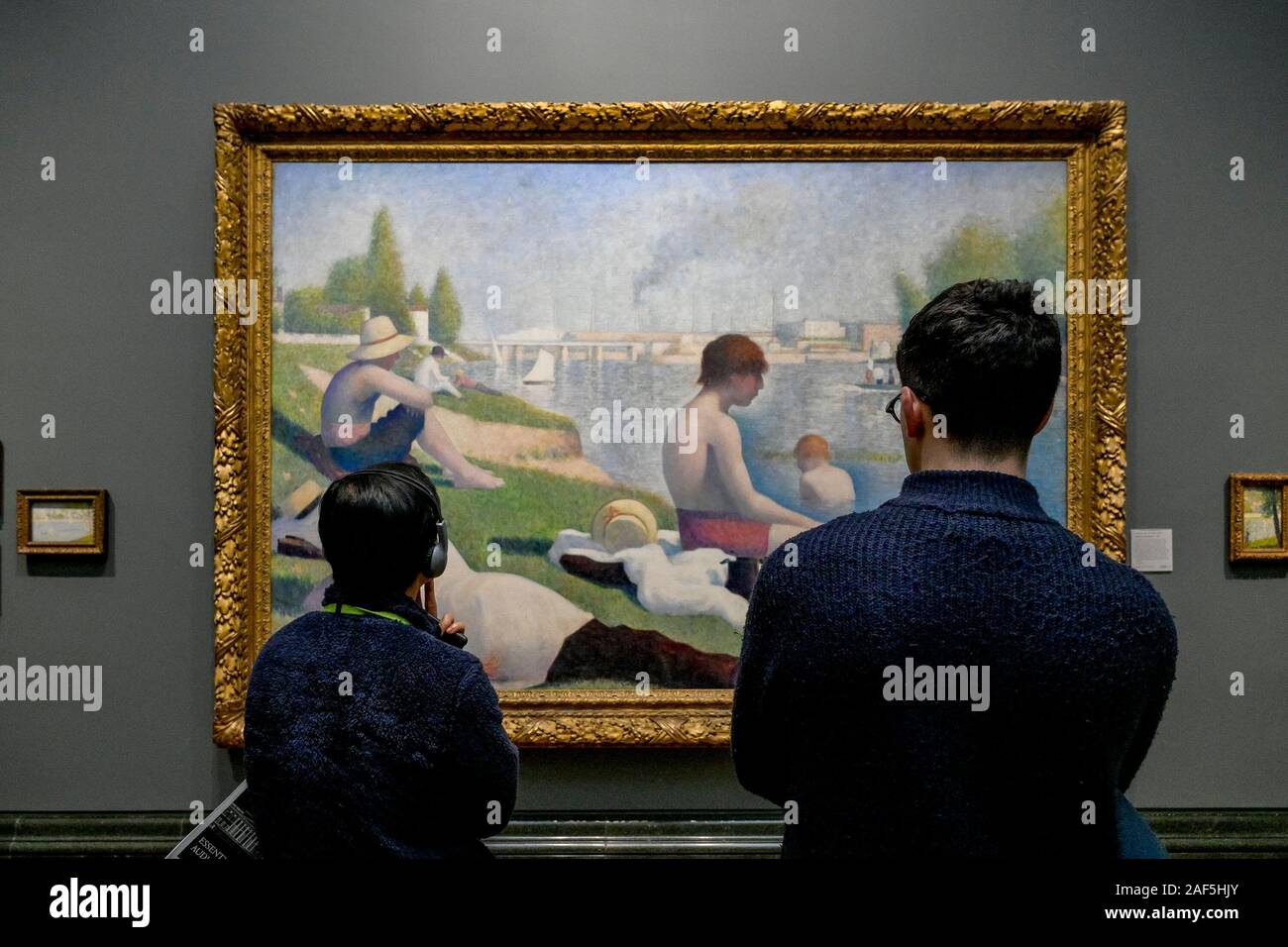People looking at Georges Seurat painting, Bathers at Asnières, National Gallery, London, England, UK Stock Photo