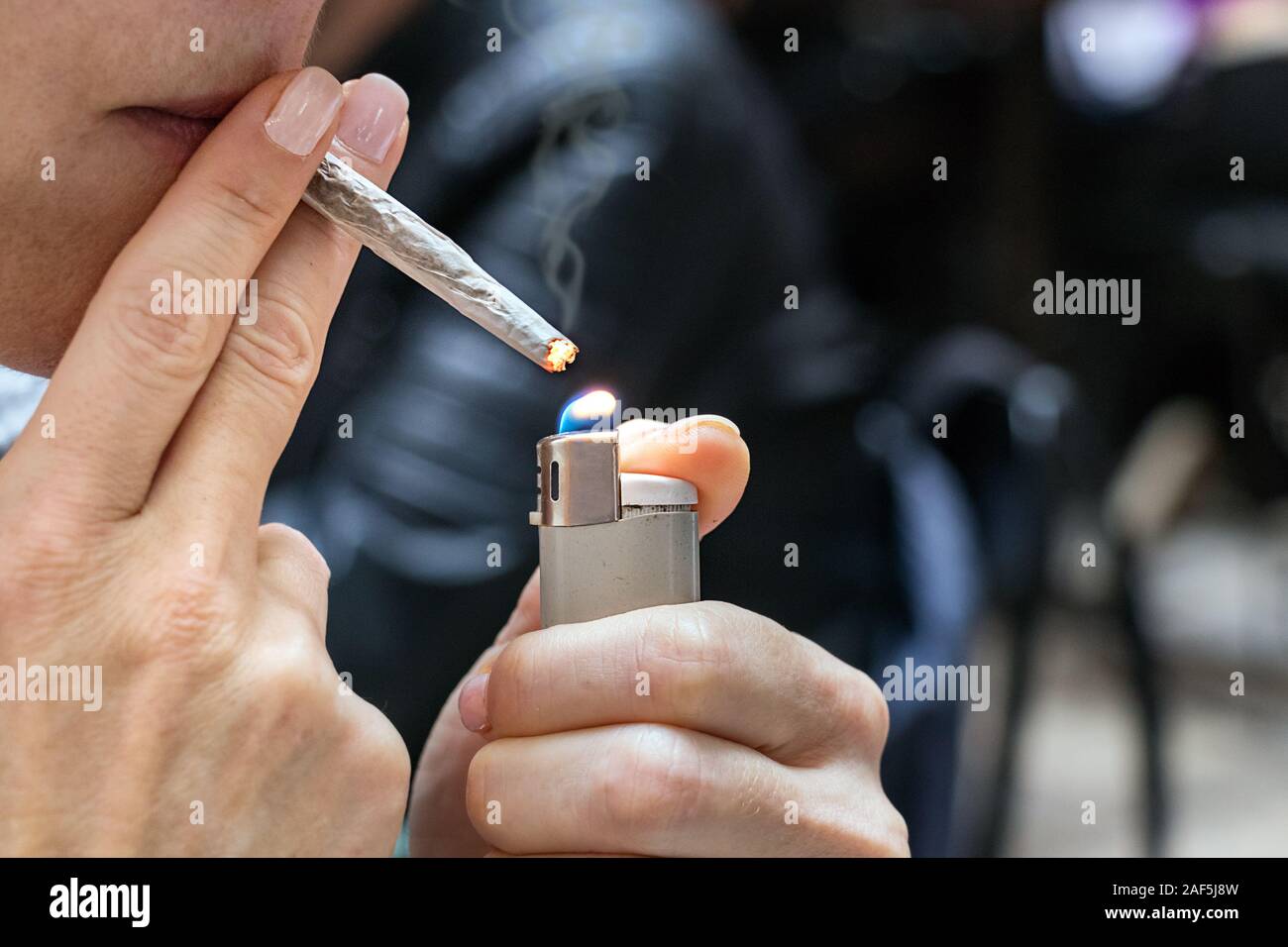 cigarette lighter burn Female hand burning a cigarette with a lighter outdoors, anxiety, bad habit  concept Stock Photo