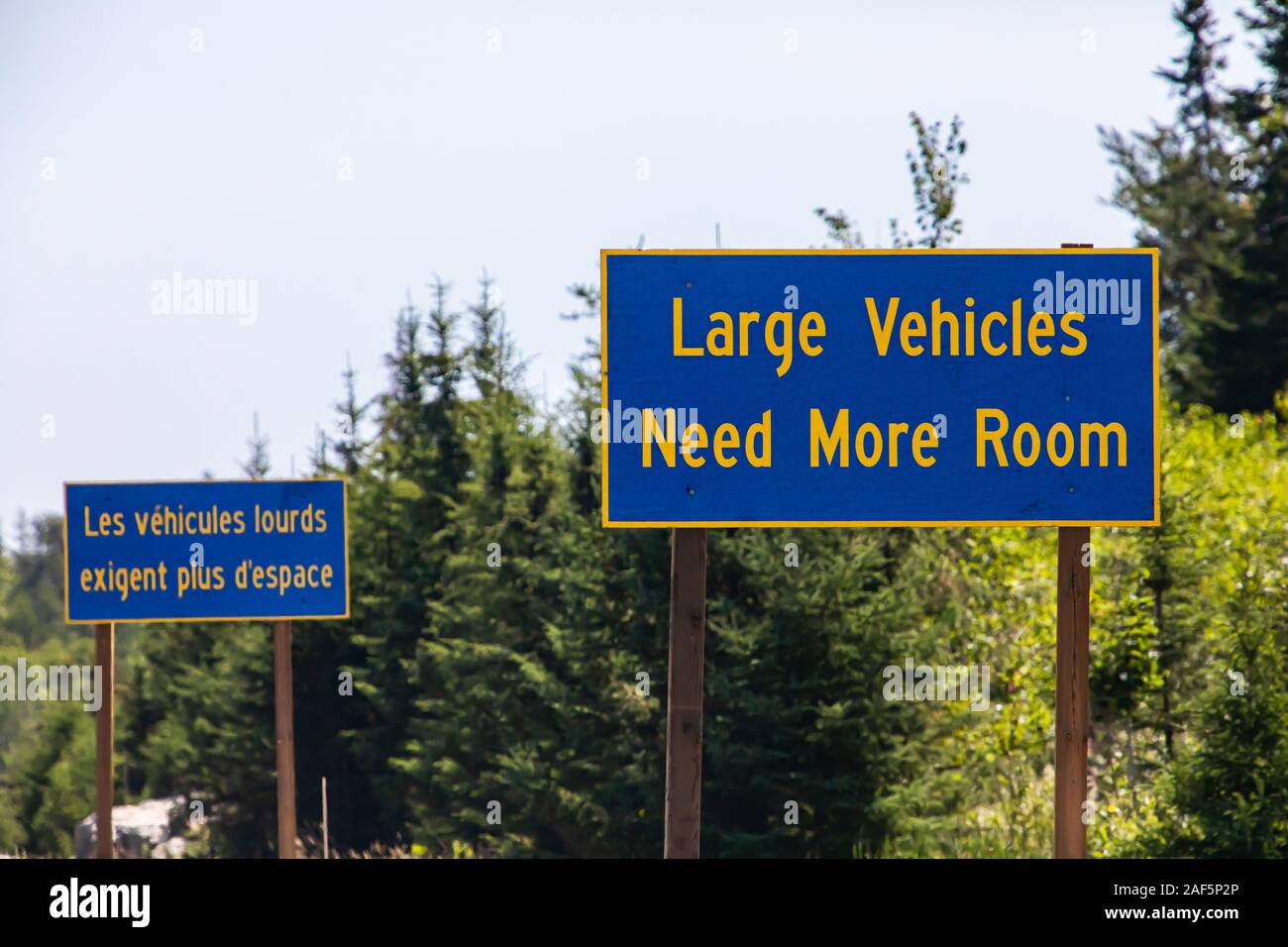 French and English two Information road Signs, large vehicles need more space. on the Canadian rural country roadside, Ontario, Canada Stock Photo
