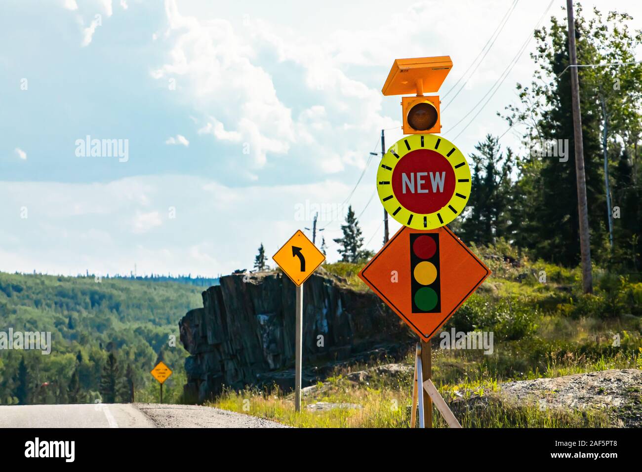 Temporary condition road warning signs on the roadside before road work  zone, new signal traffic lights ahead. with lamp, and left curve ahead sign  Stock Photo - Alamy