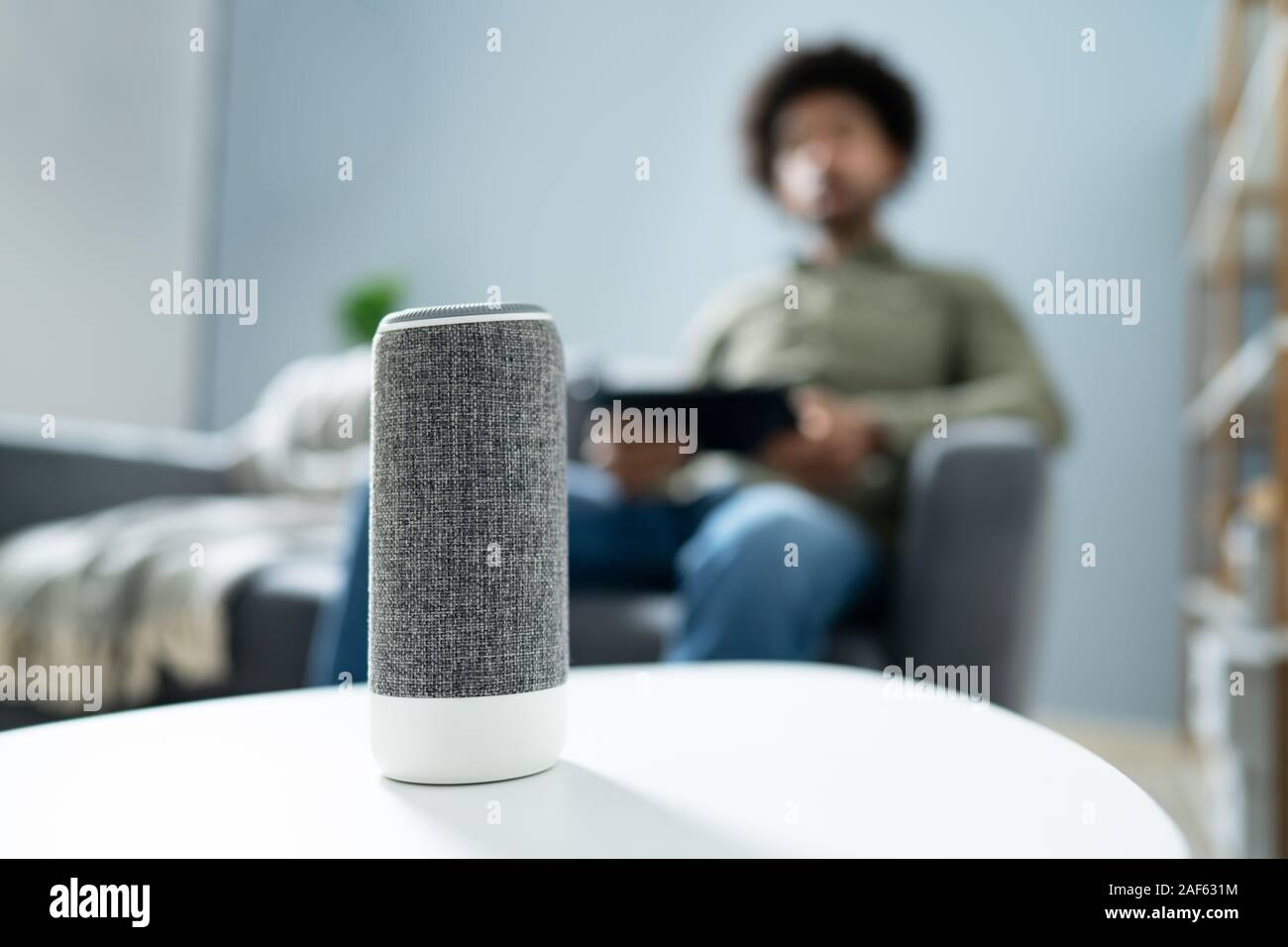 Young Man Using Wireless Speaker At Home Stock Photo