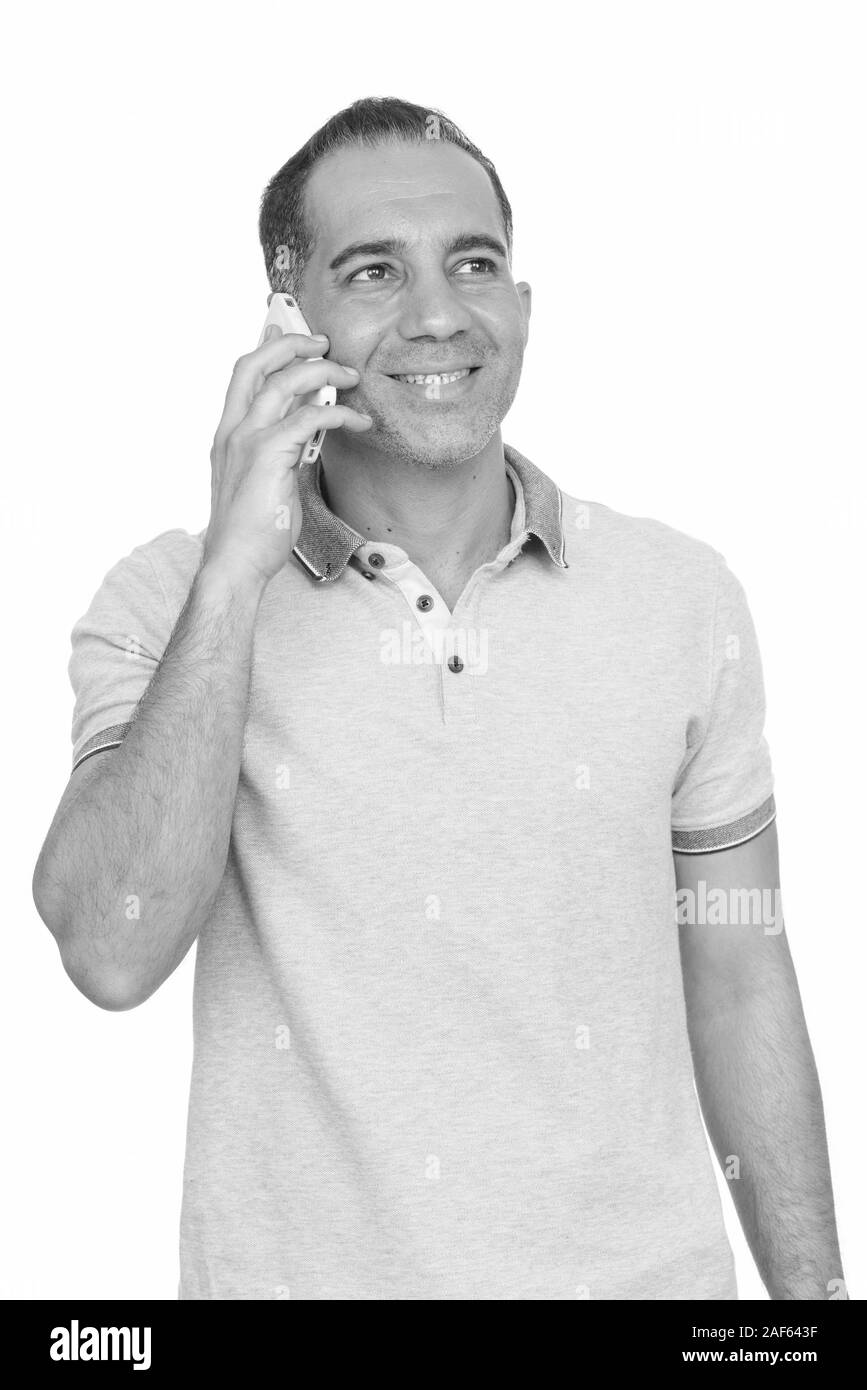 Mature happy Persian man talking on mobile phone Stock Photo