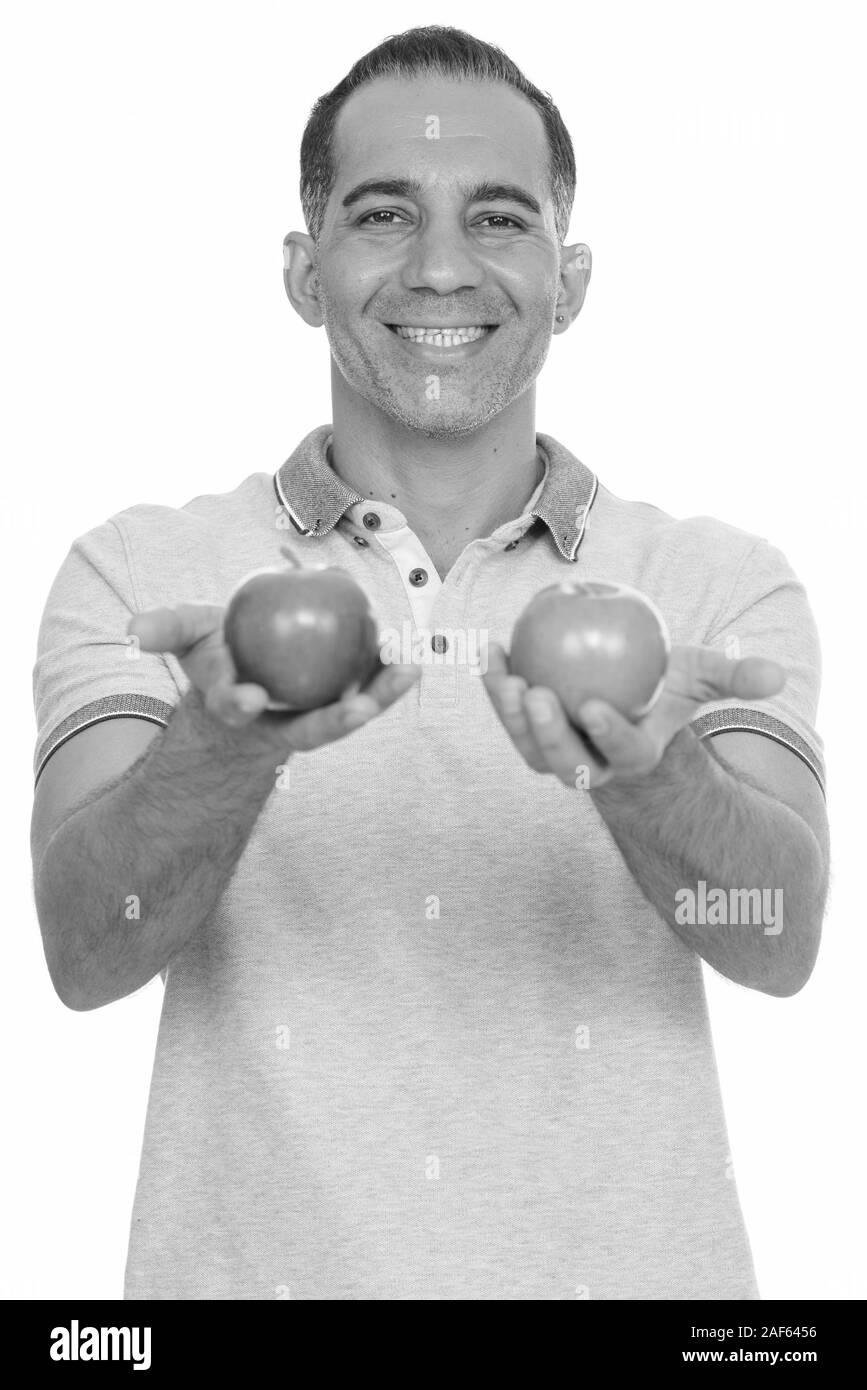 Mature happy Persian man holding red and green apple Stock Photo - Alamy