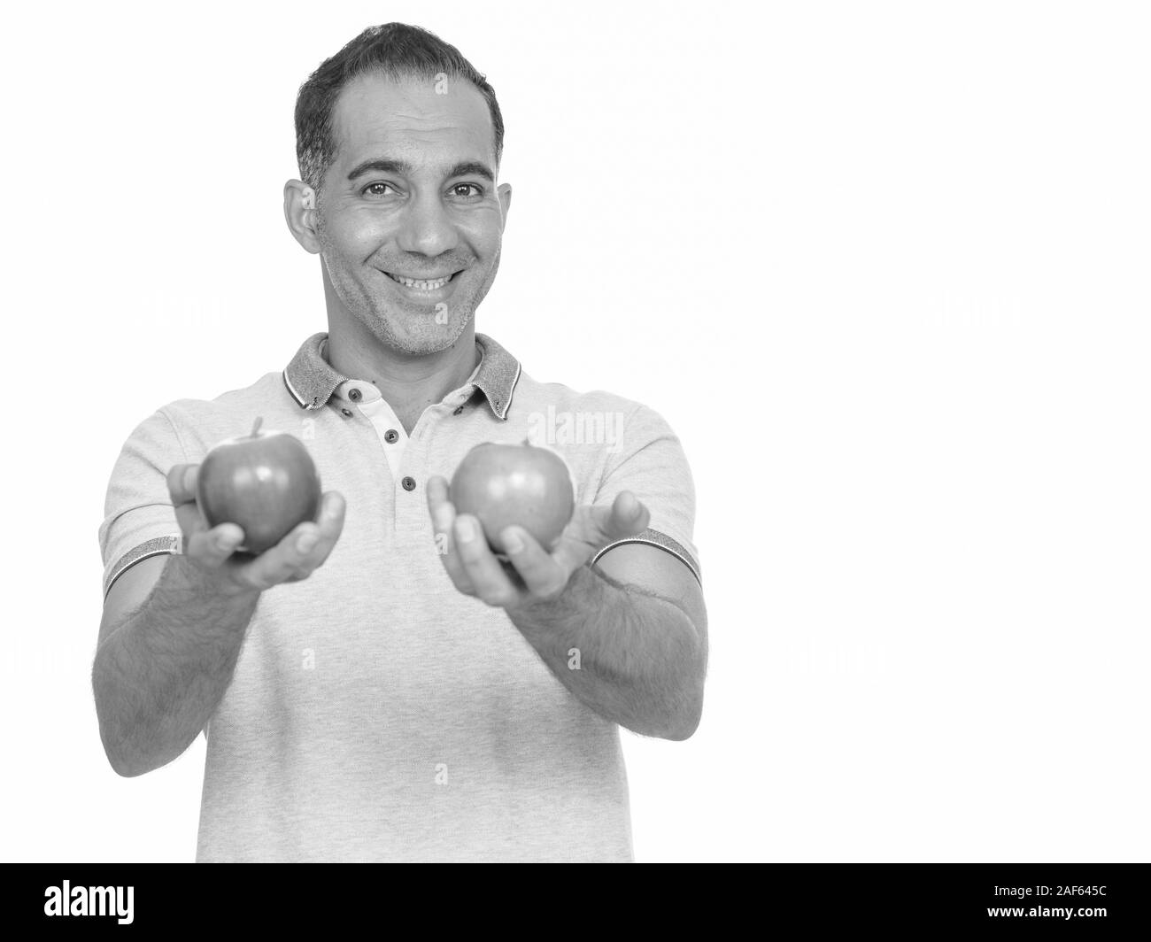 Mature happy Persian man holding red and green apple Stock Photo - Alamy