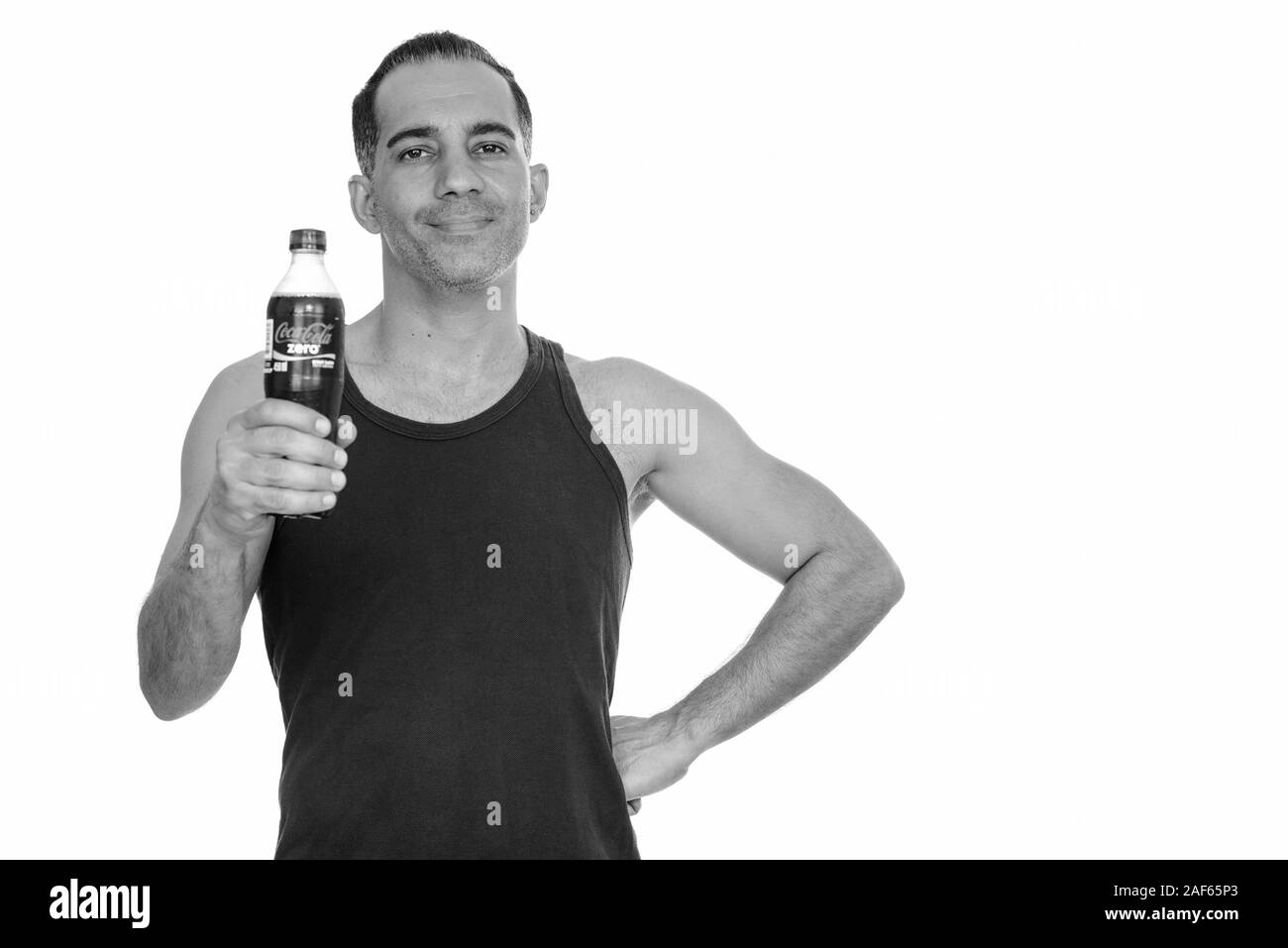 Mature handsome Persian man holding Coca-cola zero drink Stock Photo
