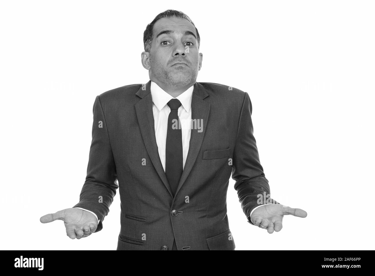 Mature handsome Persian businessman shrugging in black and white Stock Photo