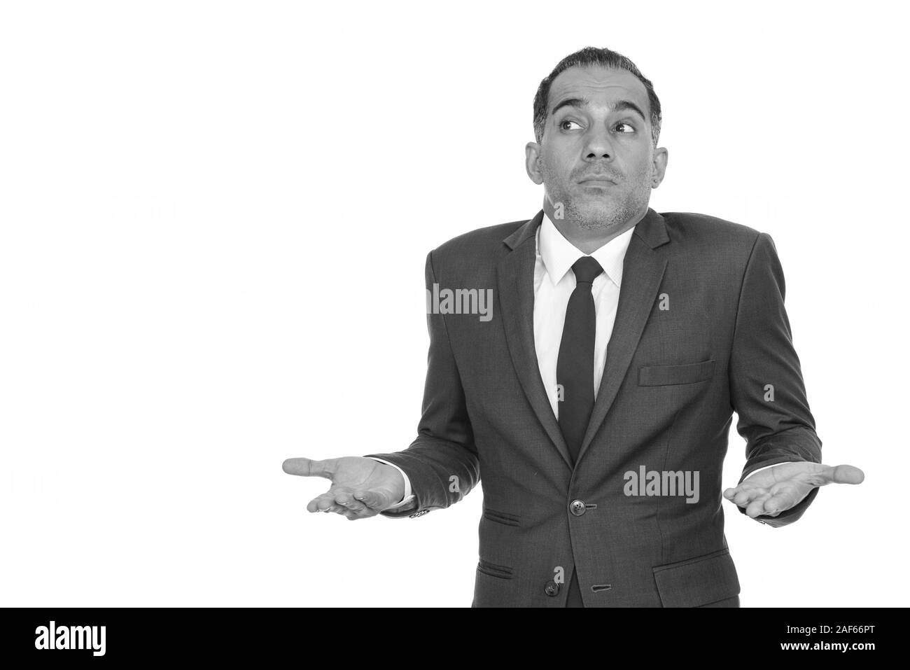 Mature Persian businessman shrugging shoulders in black and white Stock Photo