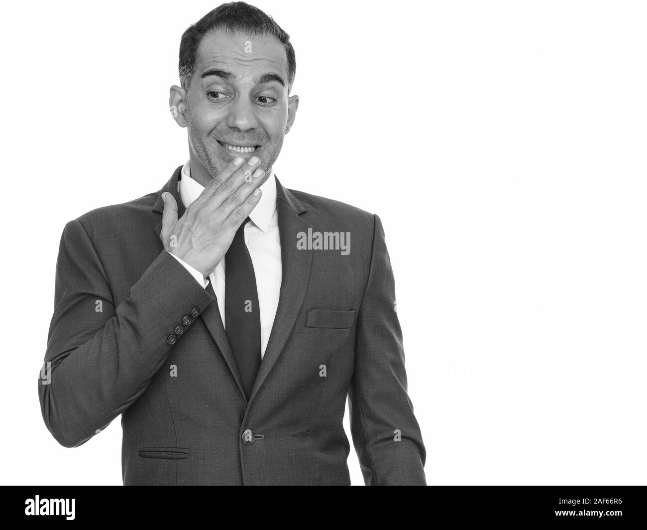 Mature handsome Persian businessman giggling in black and white Stock Photo
