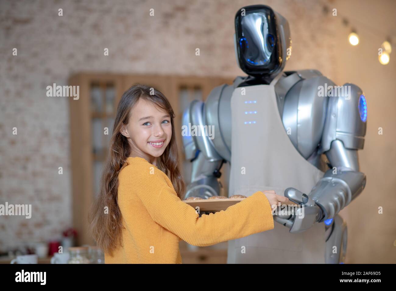 Cute girl and house robot cooking dinner together Stock Photo - Alamy