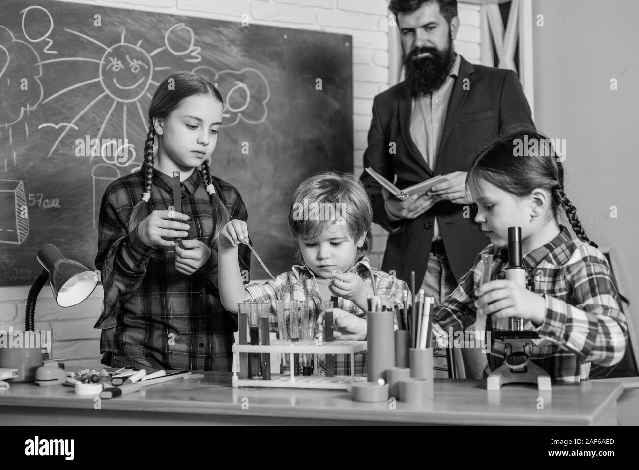 happy children teacher. doing experiments with liquids in chemistry lab
