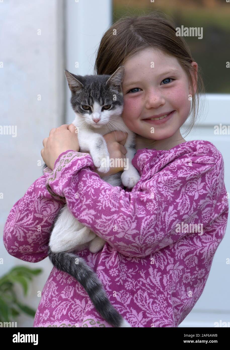 Girl, 7 years old, holding her cat in her arms, MecklenburgWestern Pomerania, Germany Stock