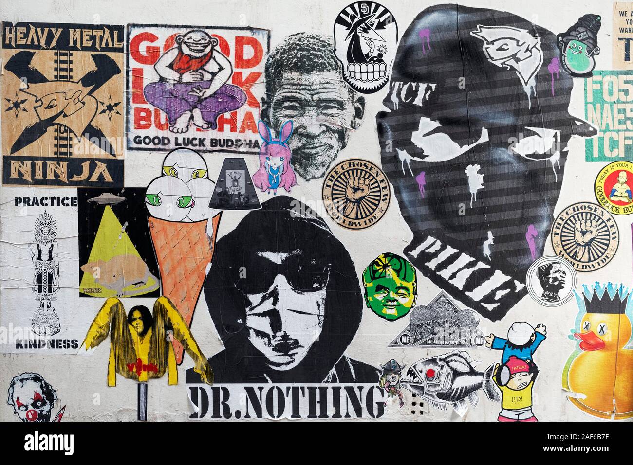 Wall covered with many paste-ups, masked demonstrator, Streetart, Brussels, Belgium Stock Photo