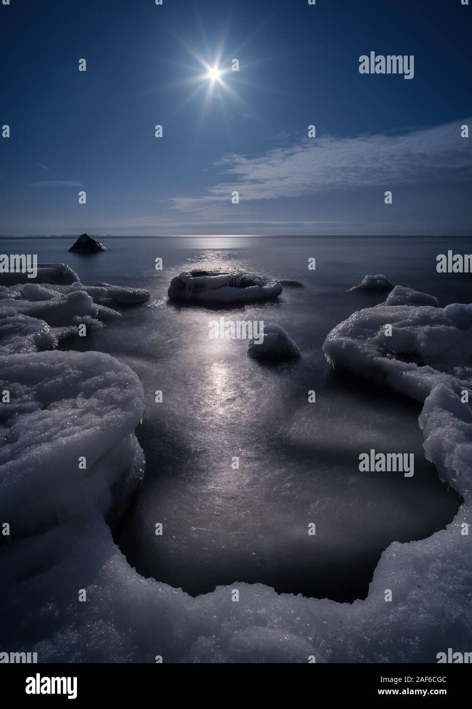 Scenic view with moonlight and icy sea at winter night in coastline, Finland Stock Photo