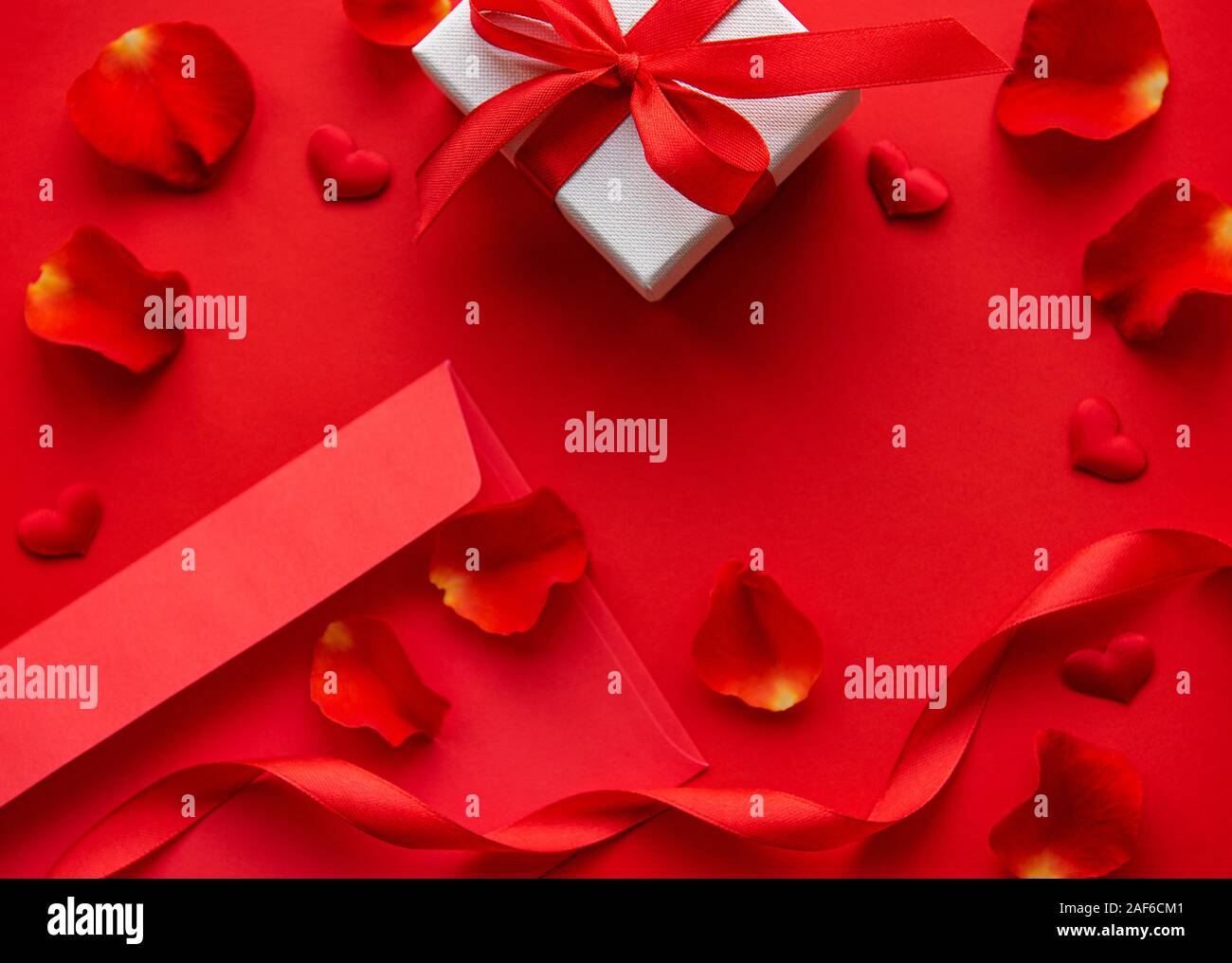 Valentines day romantic background - red rose petals, gift and envelope ...