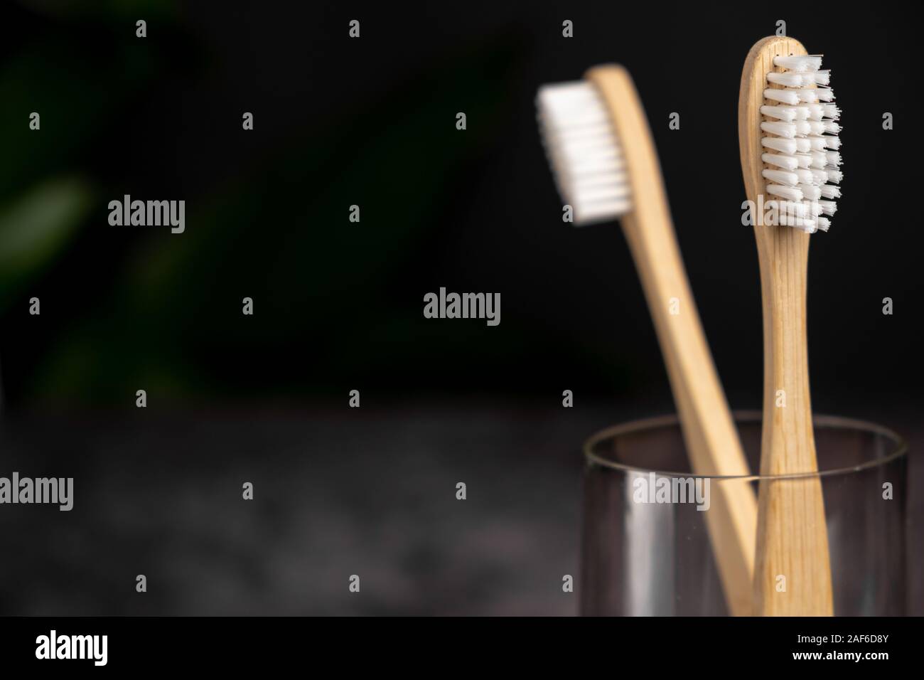 Eco natural bamboo toothbrushes in glass on black background ...