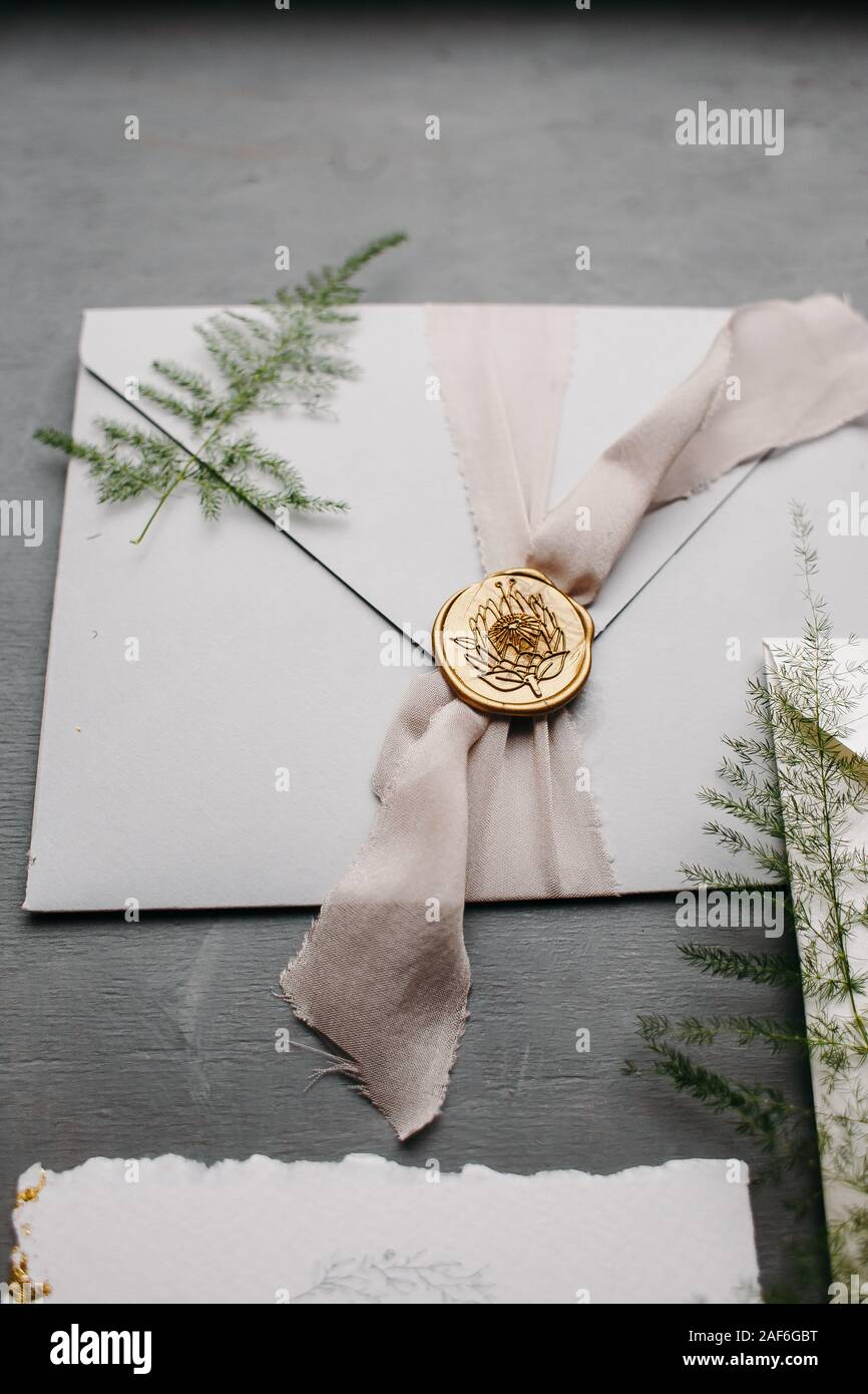 Wedding details flat lay. Wedding invitation and scroll paper. Bottle with fragrance. Simple bouquet. Ring box. Stock Photo