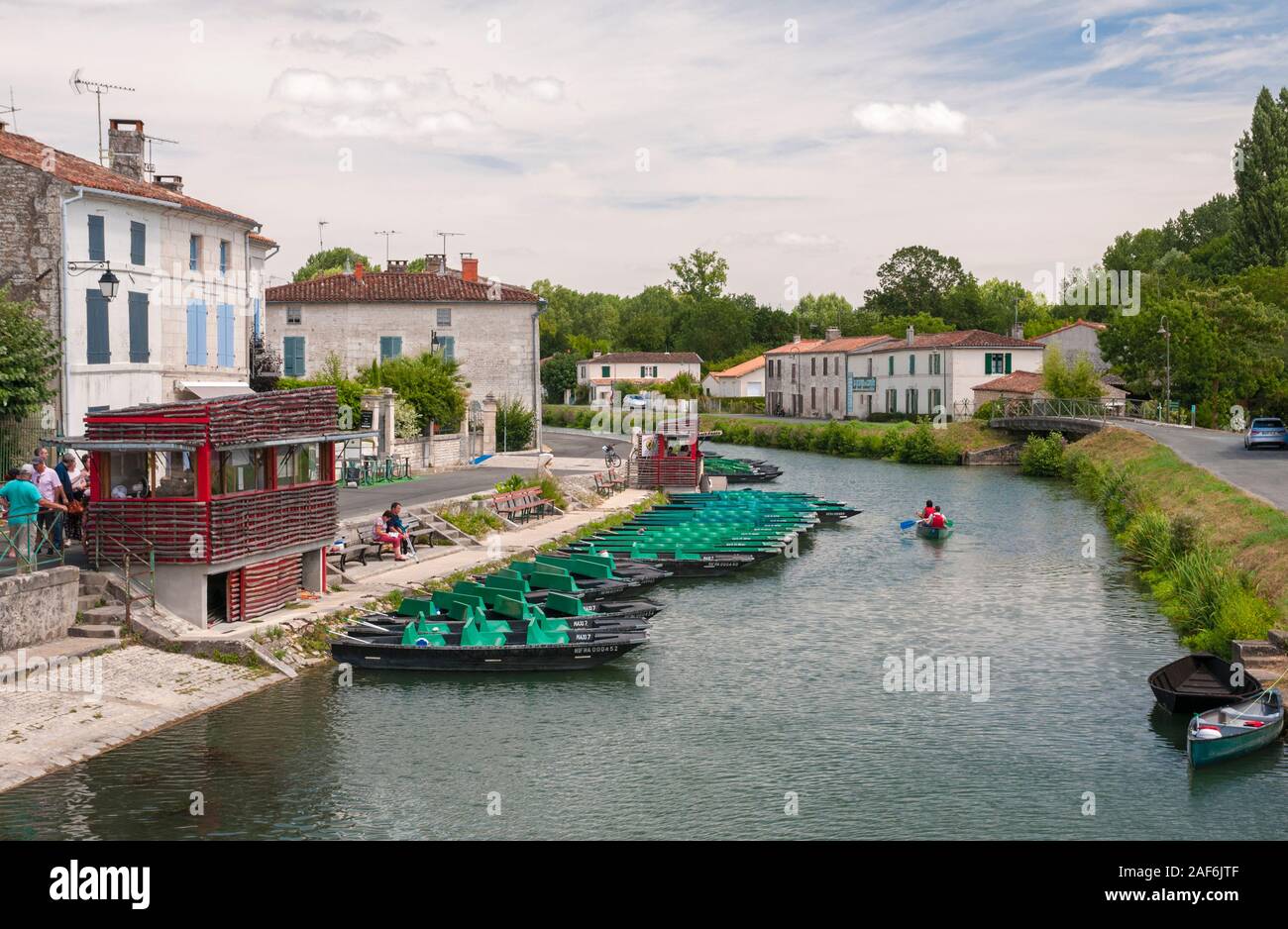 Green tourist pleasure boats on the Sevre Niortaise river in the picturesque town of Coulon, Deux-Sevres (79) in Marais Poitevin, France Stock Photo