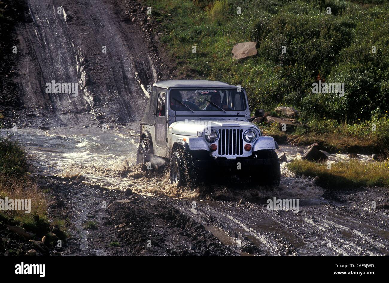 CJ5 Jeep crossing a river on a Jeep Jamboree event in Alberta Canada 1993 Stock Photo